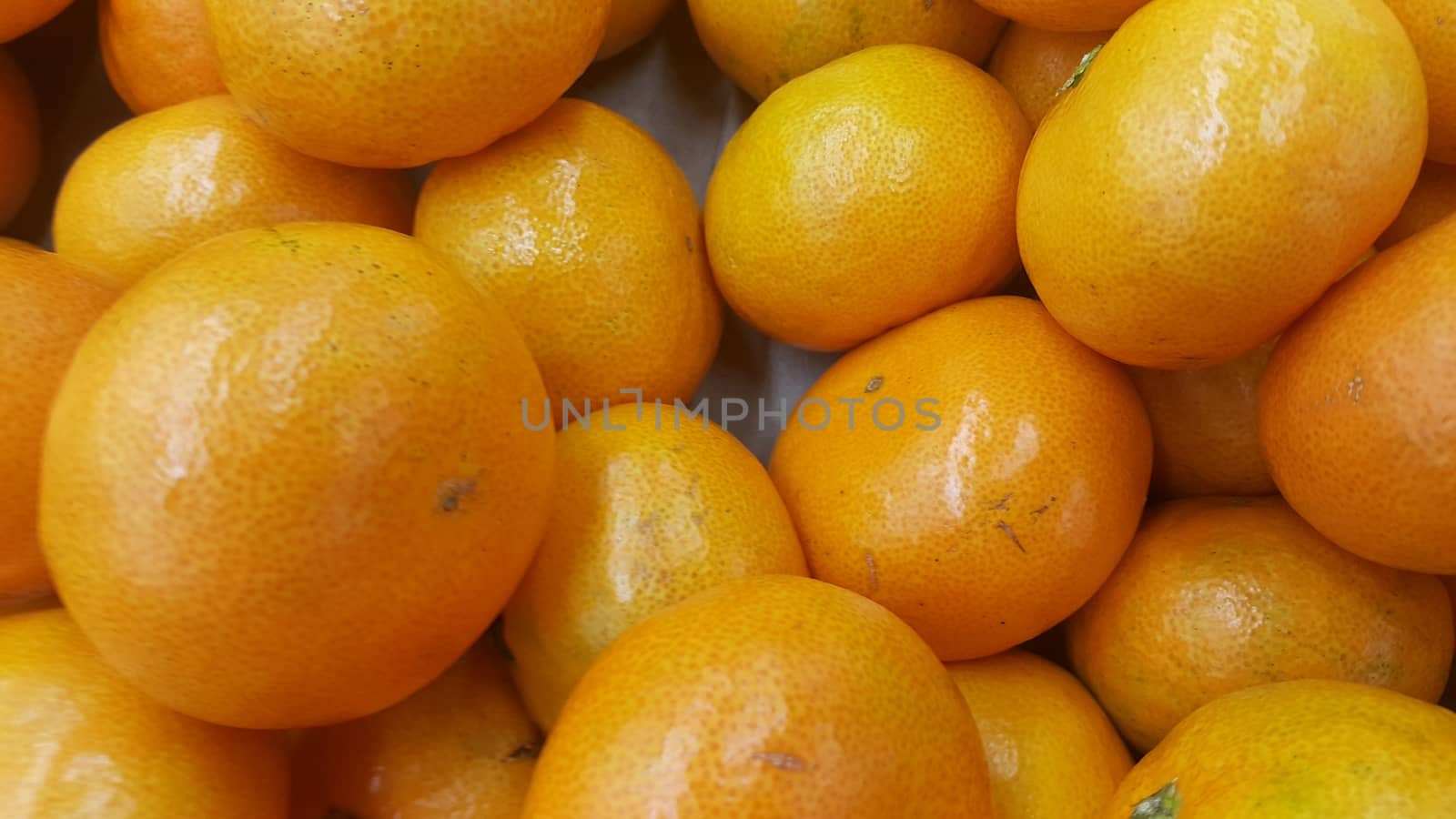 Fresh oranges in supermarket for sale, pile of orange in market for texture by Photochowk