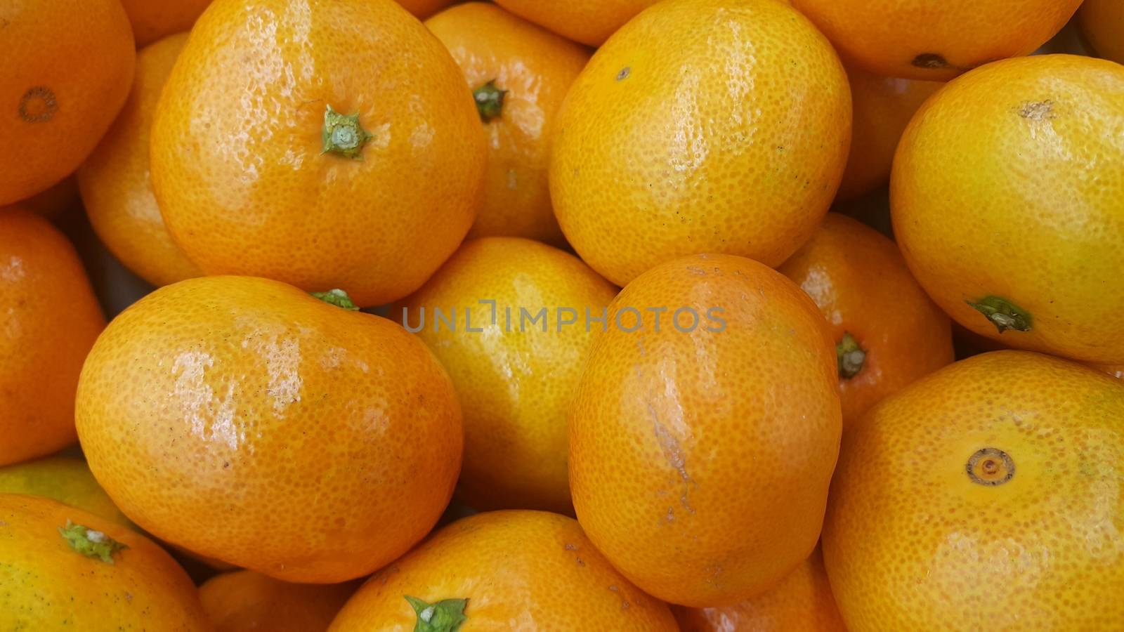 Fresh oranges in supermarket for sale, pile of orange in market for texture by Photochowk