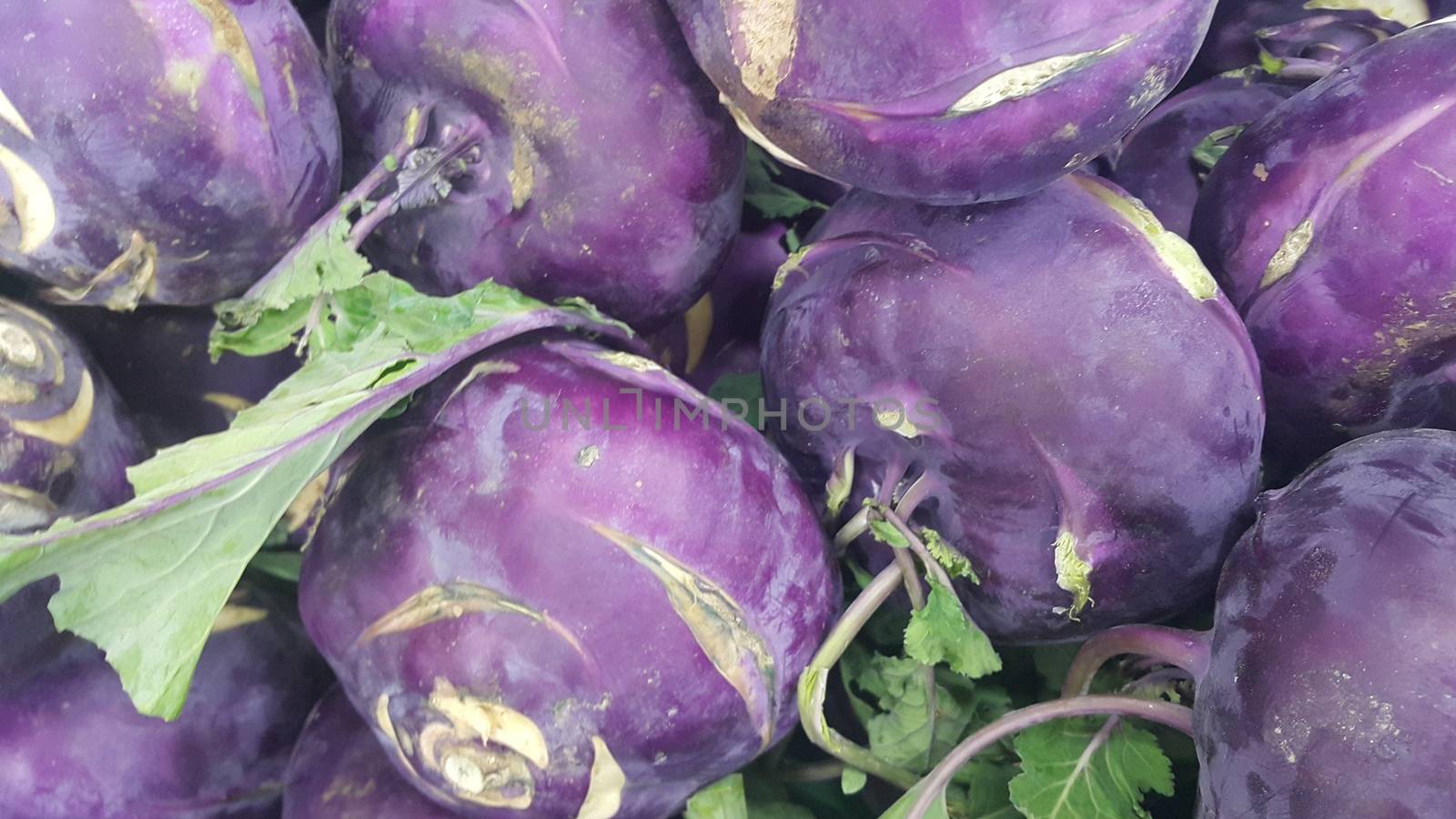 Fruits background: Purple fresh kohlrabi turnip in supermarket for sale by Photochowk