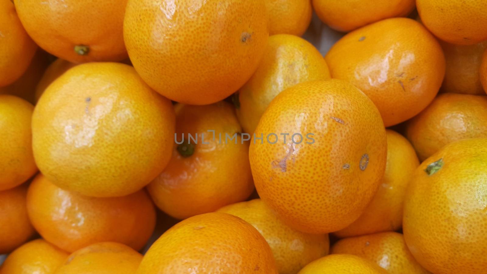 Fresh oranges in supermarket for sale, pile of orange in market for texture by Photochowk