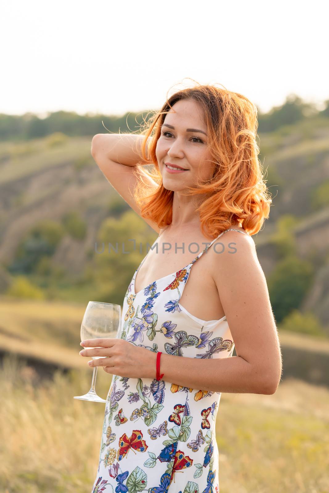 Beautiful red-haired girl is having fun and dancing in a field at sunset by Try_my_best