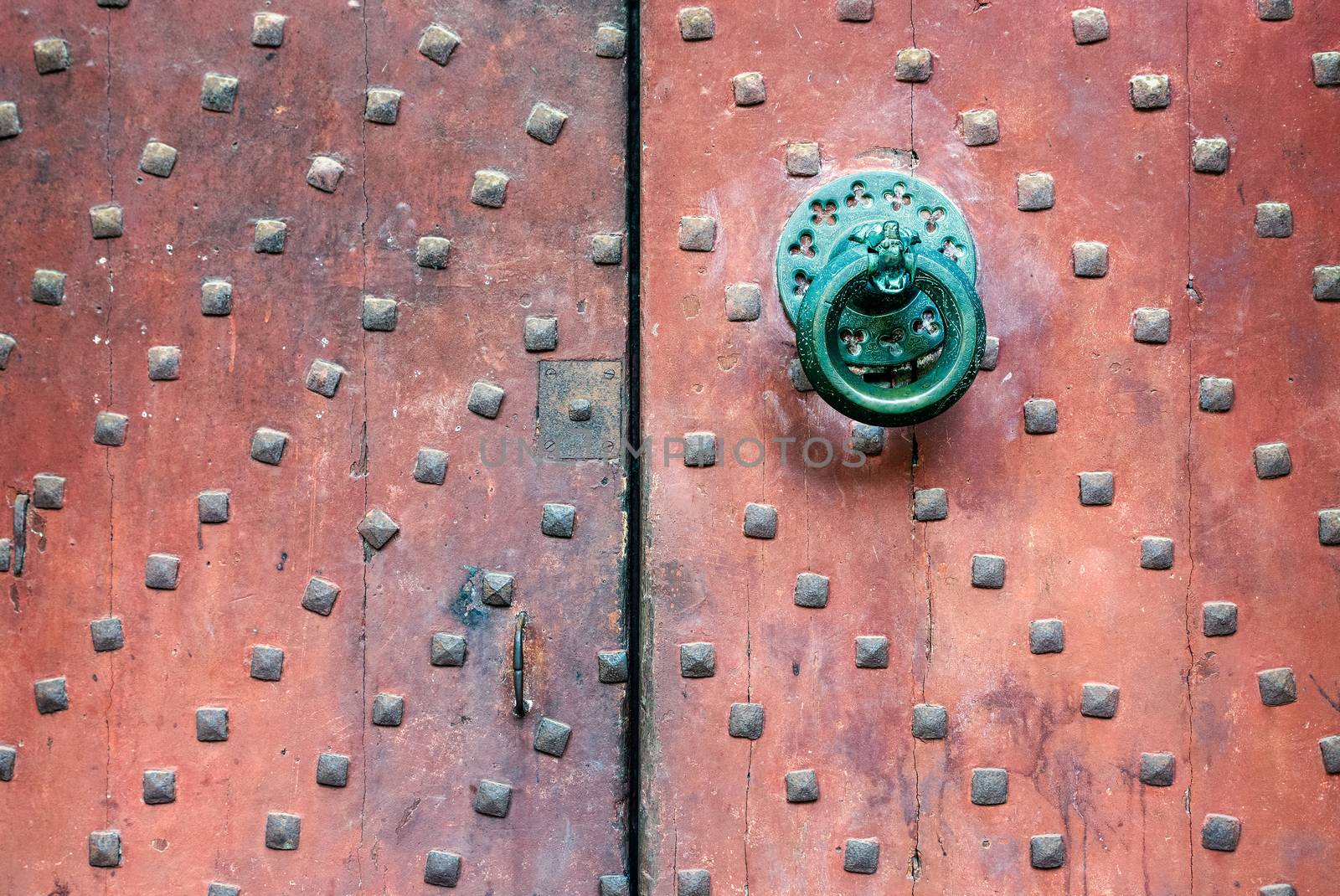 Old church door handle detail shot, wrought iron handle and big square nails