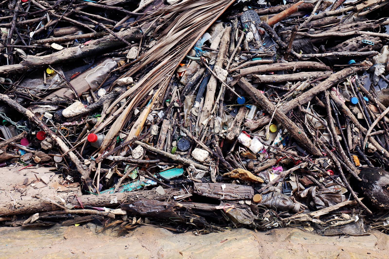 Garbage pile deposit Branches wood, Pile of wood and plastic bottles waste and debris floating on water surface at river water dirty, Problem of trash pollution and environmental on the beach or river
