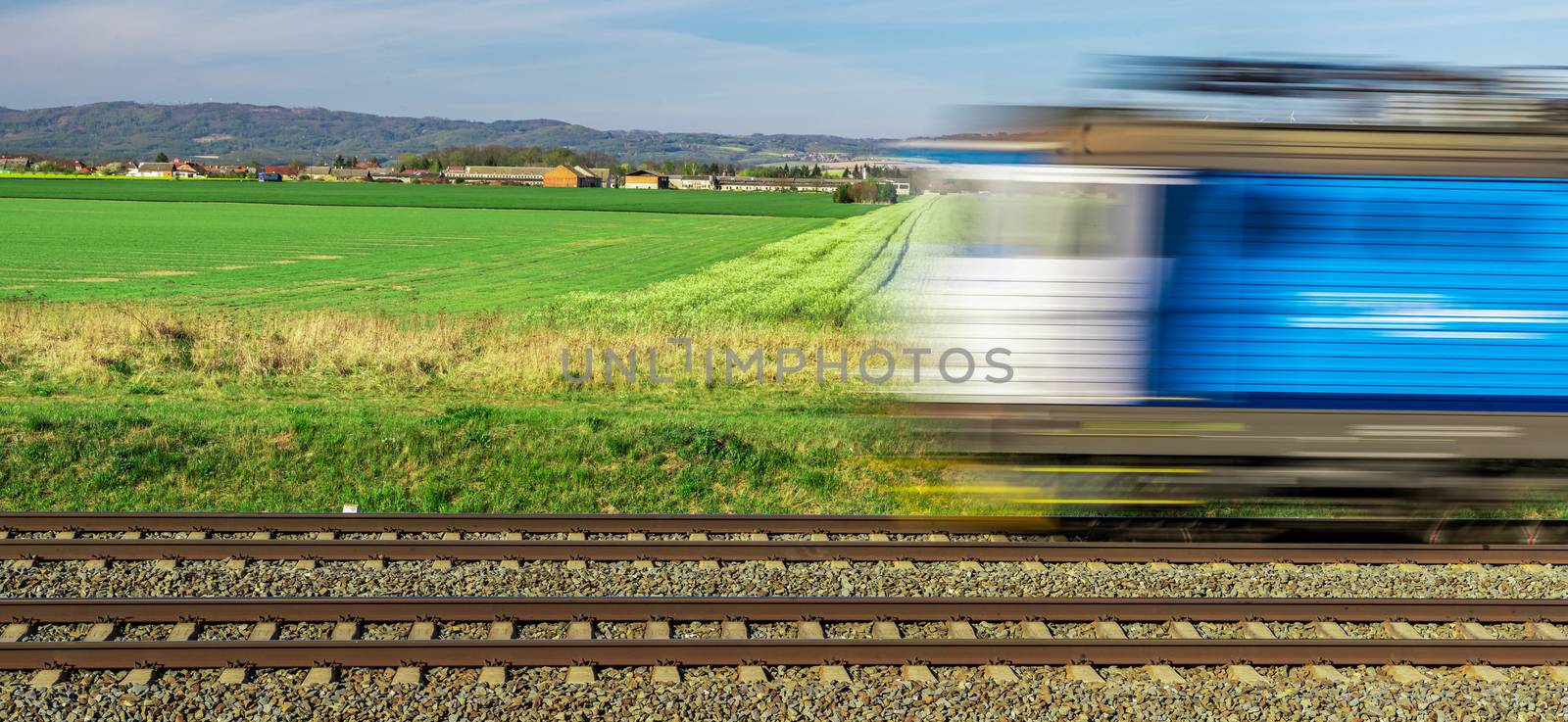 an electric train passes through a beautiful landscape on railway tracks by Edophoto