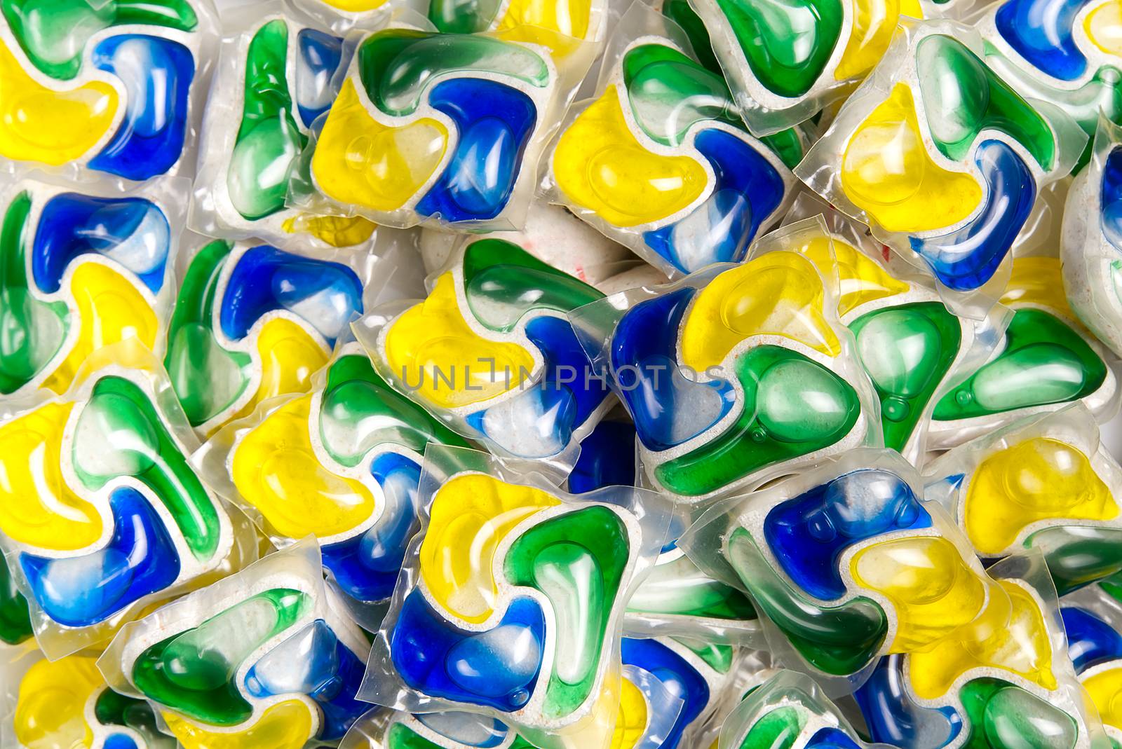 Liquid dishwashers capsules, background of all-in-one capsules with laundry detergent and dishwasher soap. by PhotoTime