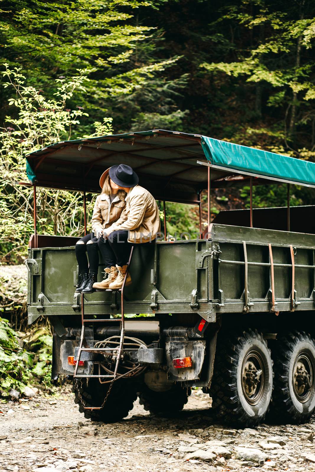 A beautiful girl and a handsome man in military truck. Lovestory. Military vehicle. Military fashion.Carpathian mountains by Denys_N
