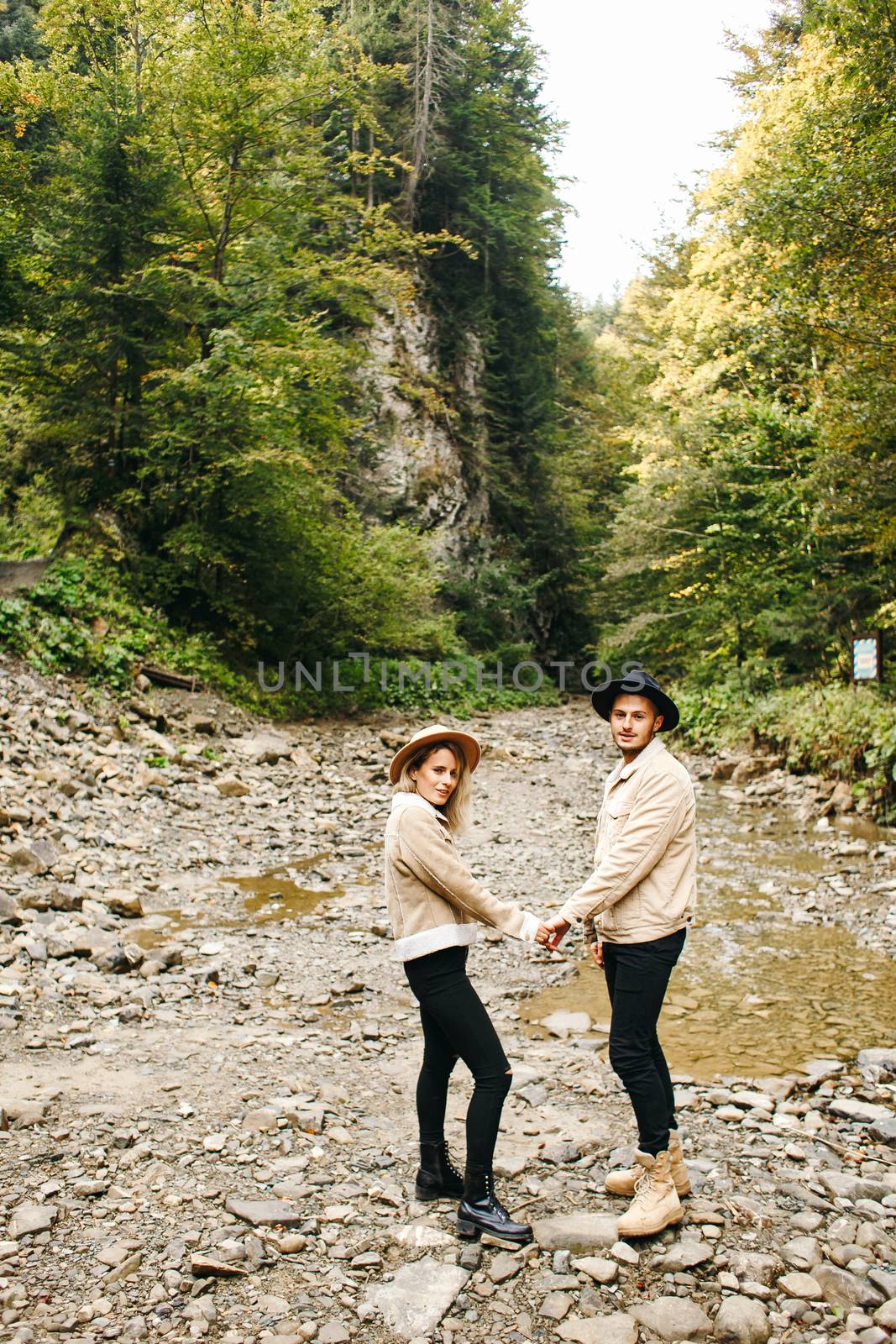 Young couple at the Carpathian - Happy tourists visiting mountains. Lovestory. Tourists in hats. Military fashion