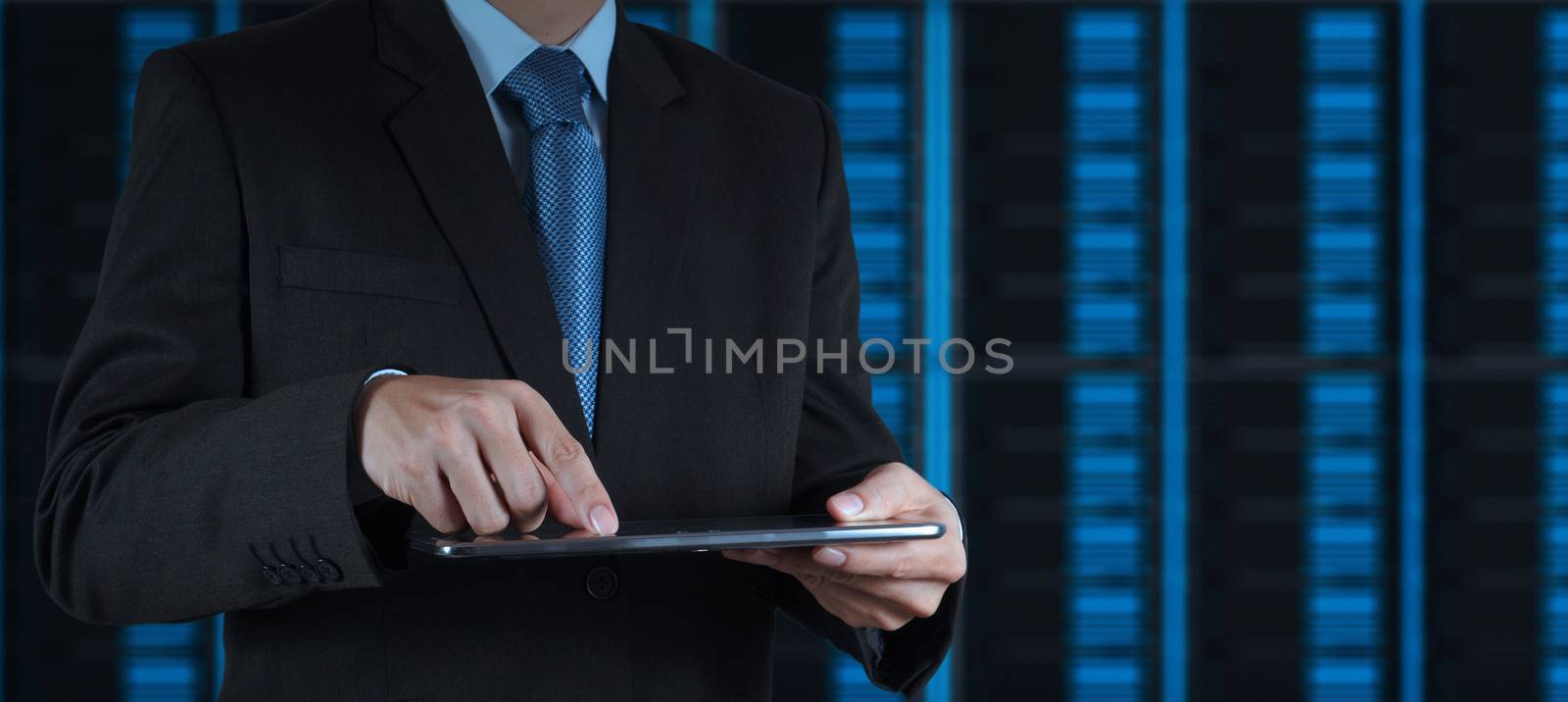businessman hand using tablet computer and server room background
