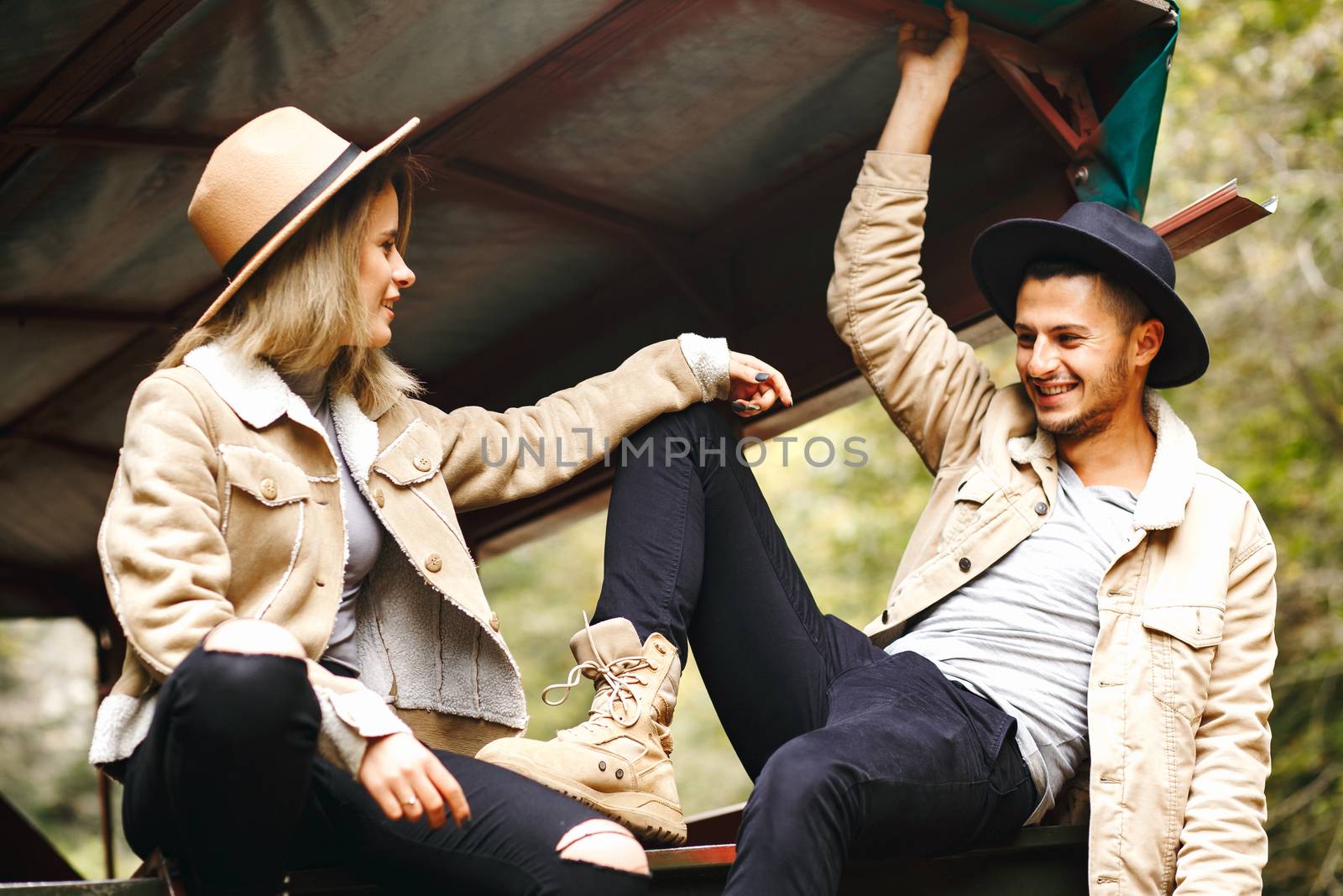 A beautiful girl and a handsome man in military truck. Lovestory. Military vehicle. Military fashion.Carpathian mountains.