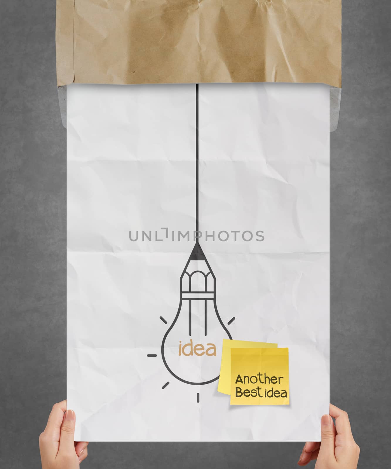 hand showing sticky note with another idea light bulb on crumpled paper as creative concept
