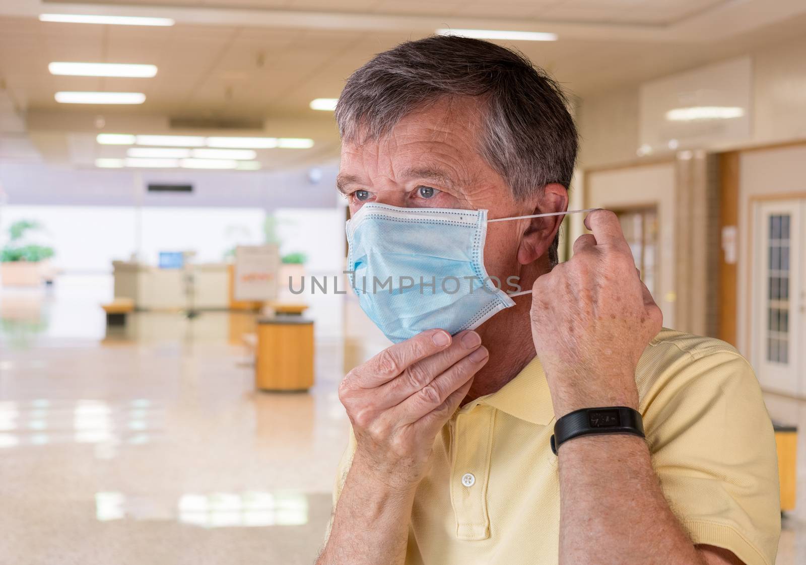 Senior caucasian man adjusting his face mask and looking concerned about coronavirus epidemic. Composite inside shopping mall