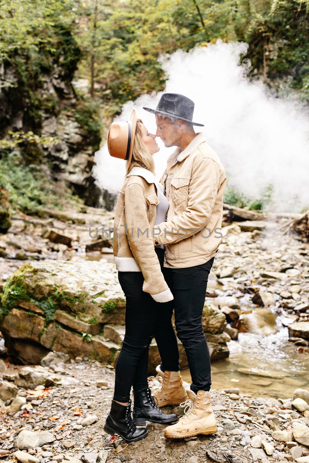 Couple in vape cloud. Two in smoke. Tourists in cold autumn forest with vape. Man and women in smoke. Two smokers. Beautiful couple in fog. E-cigarettes and people. by Denys_N