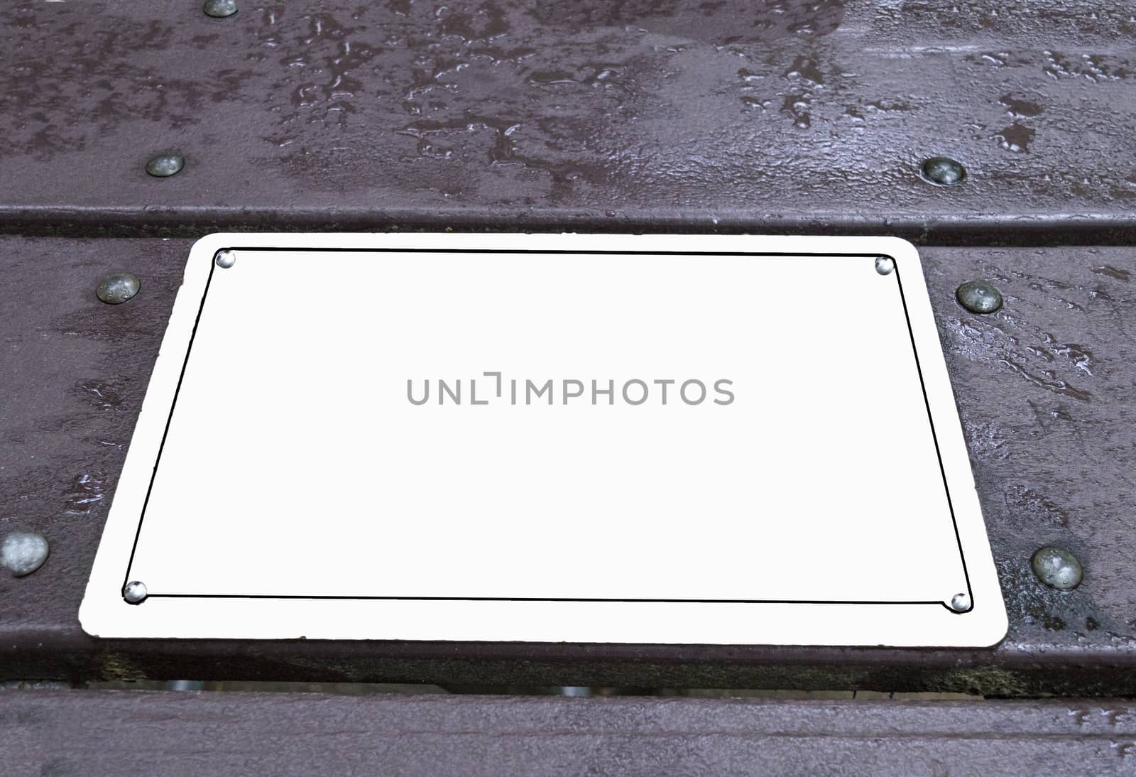 Horizontal shot of a blank sign laying on a picnic table.