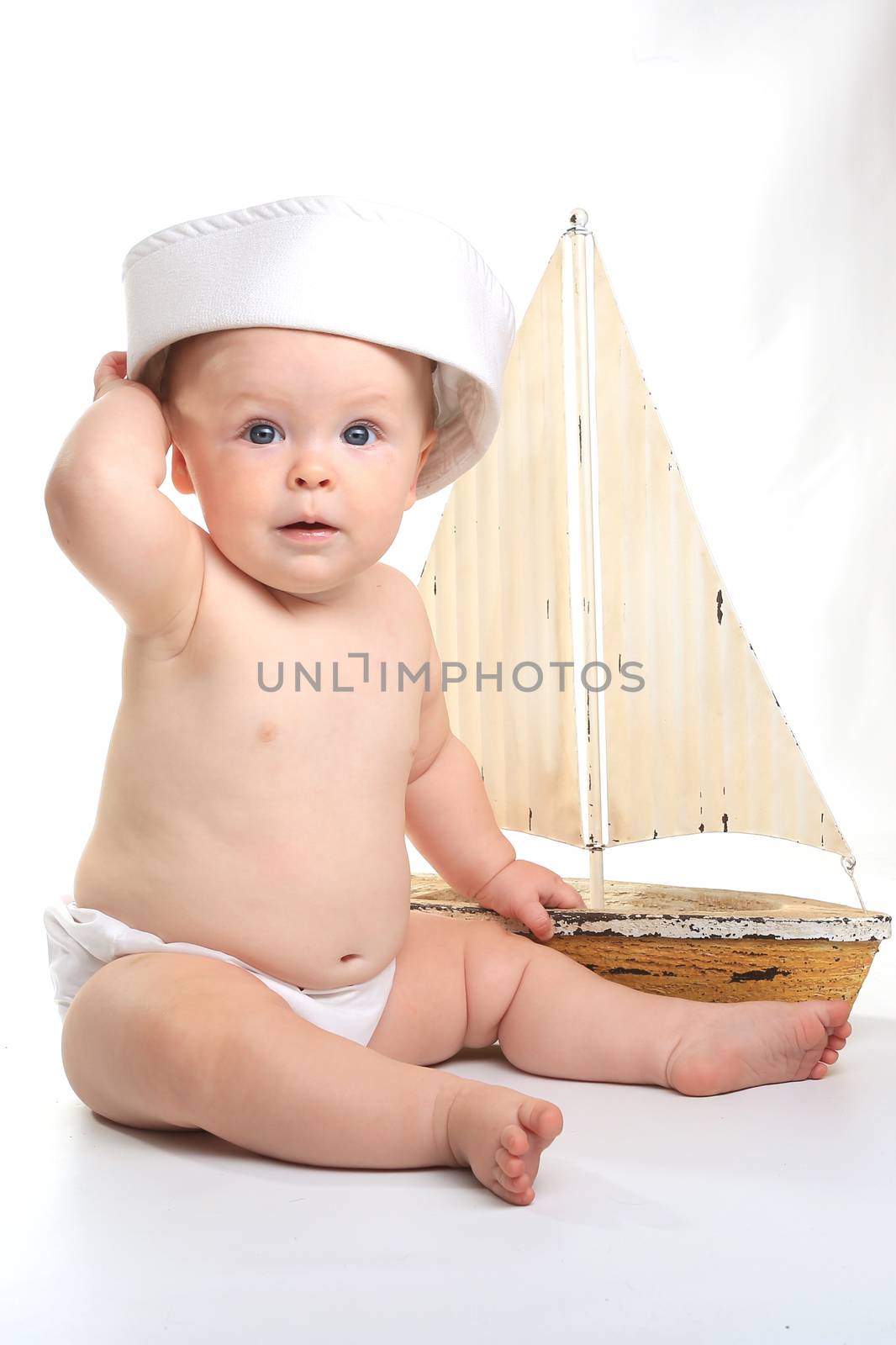 Happy Baby Toddler Sitting up Wearing Sailor Hat on White Background