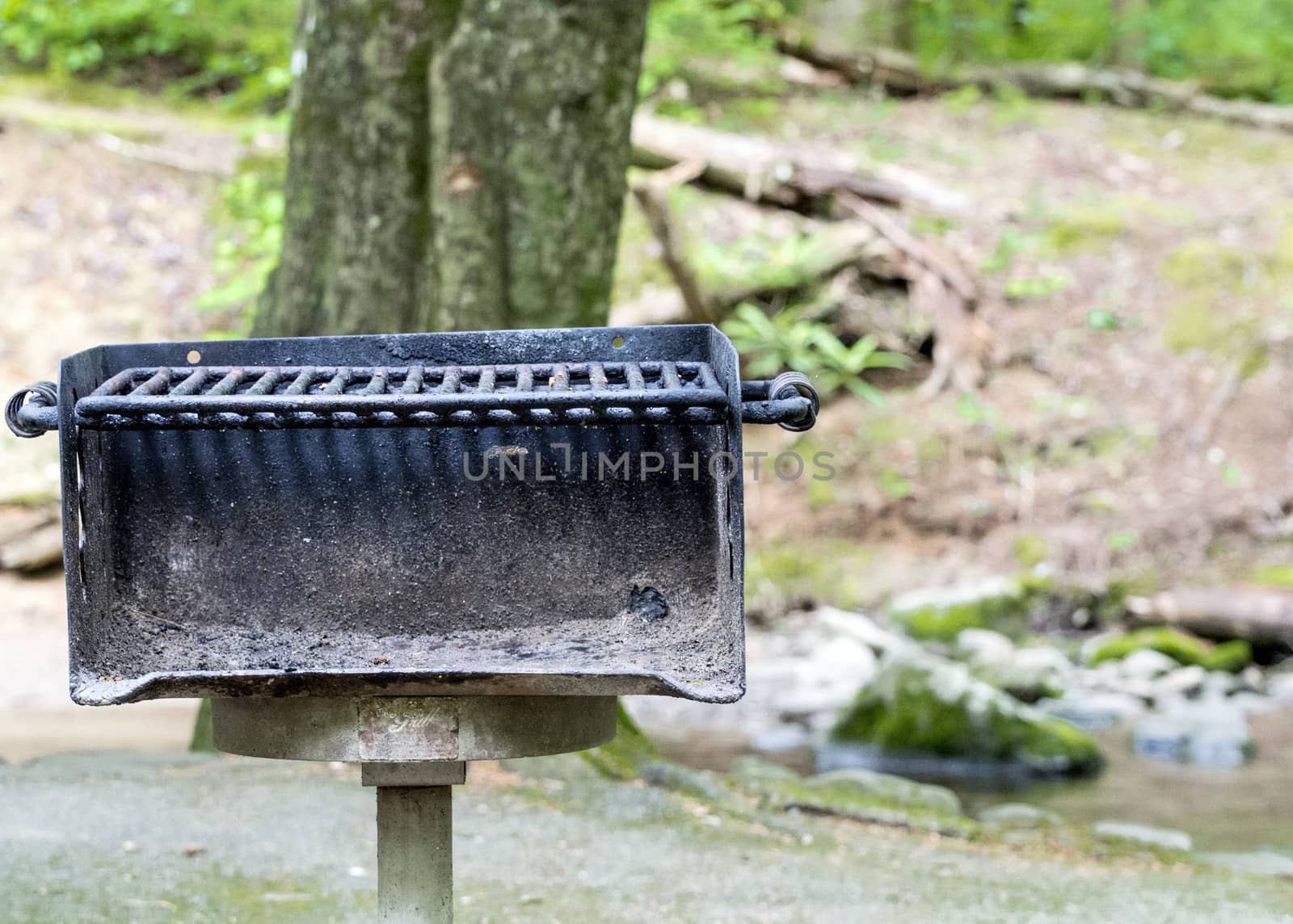 Horizontal close-up shot of a well used public area barbecue grill straight on. 