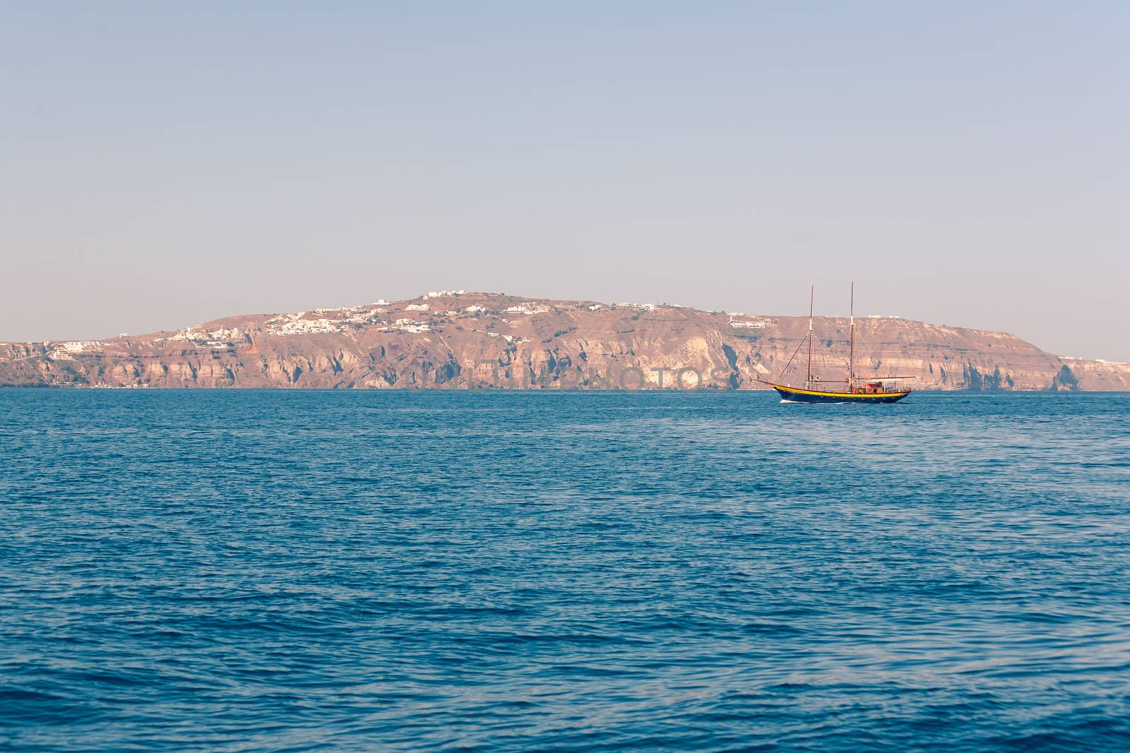 View on the seaside of Santorini island with ship on the sea by VIIIPhoto