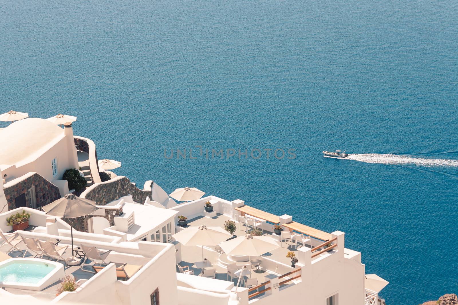 View on the seaside of Santorini island with ship on the sea by VIIIPhoto