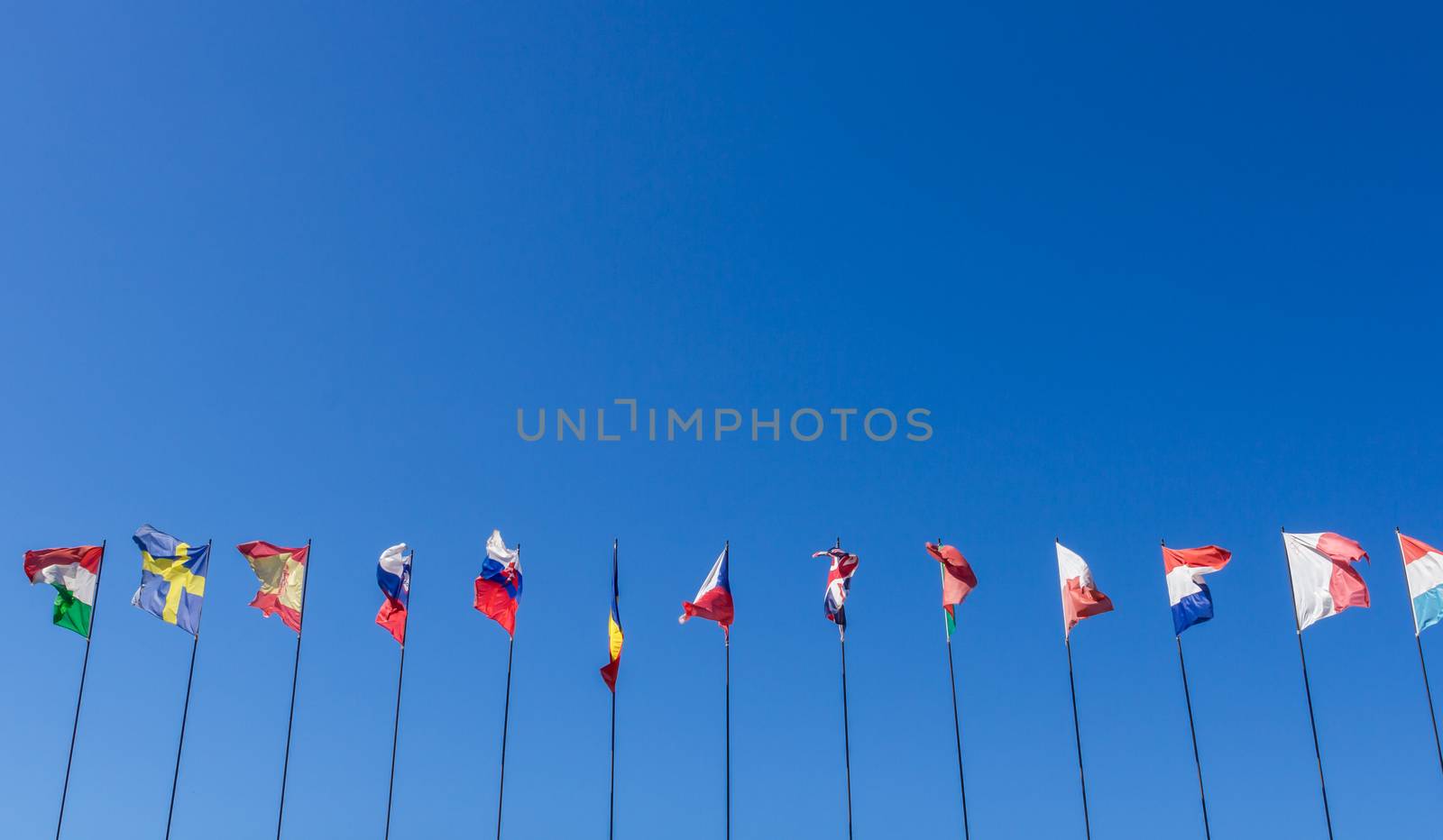 Row of national flags against blue sky