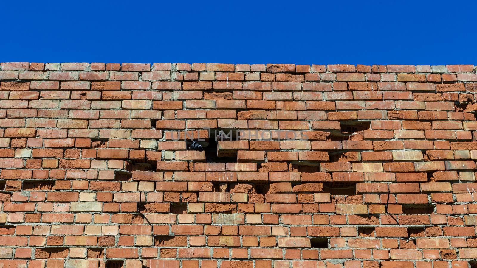 Old brick wall against bright sky