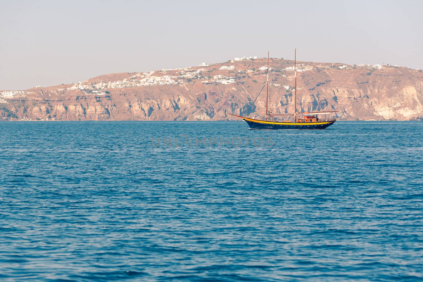 View on the seaside of Santorini island with ship on the sea by VIIIPhoto