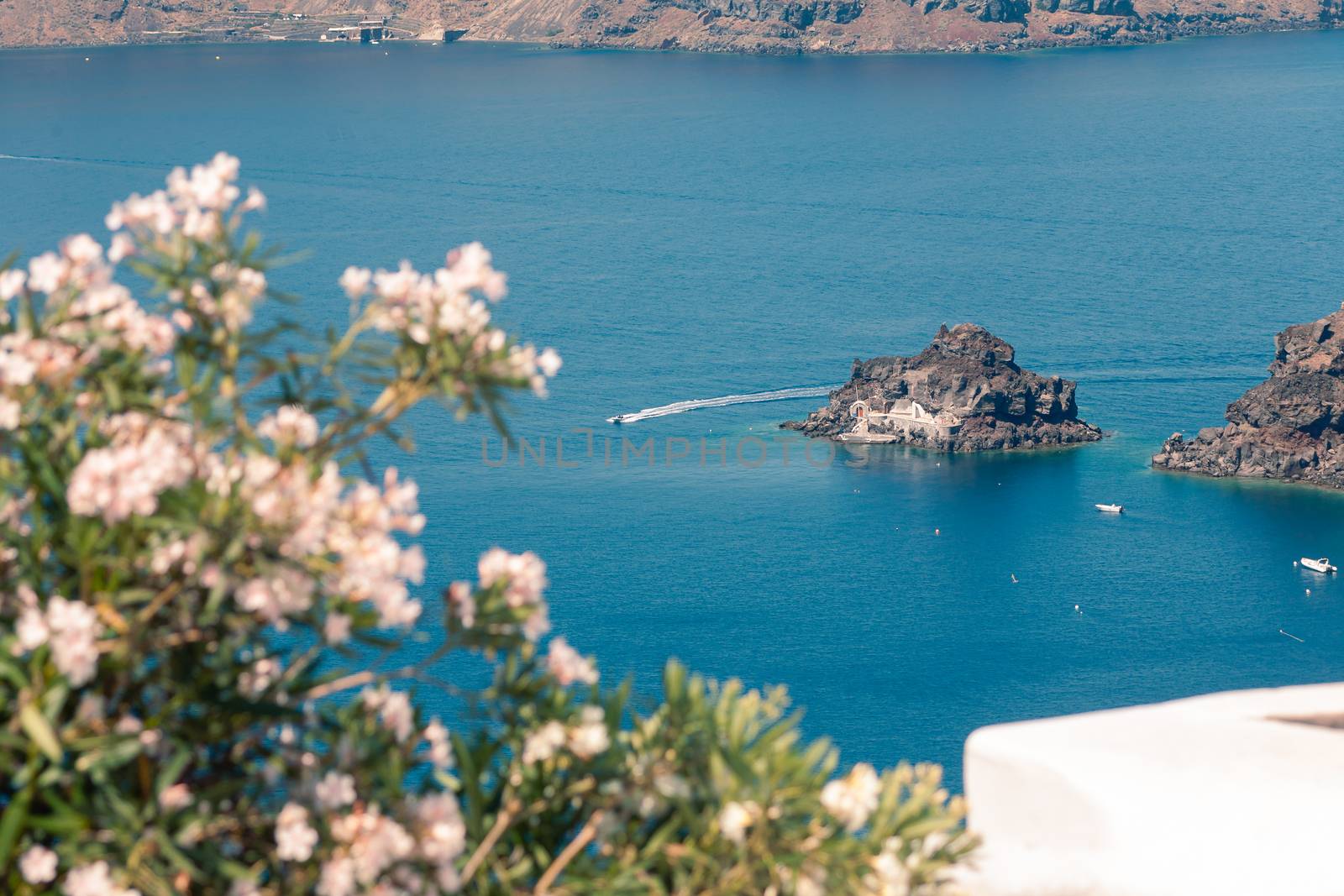 View on the seaside of Santorini island with ship on the sea by VIIIPhoto