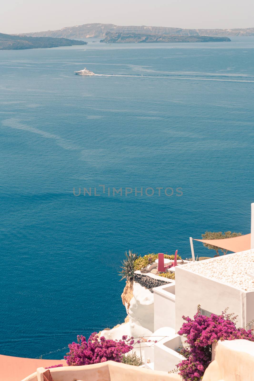 View on the seaside of Santorini island with ship on the sea by VIIIPhoto