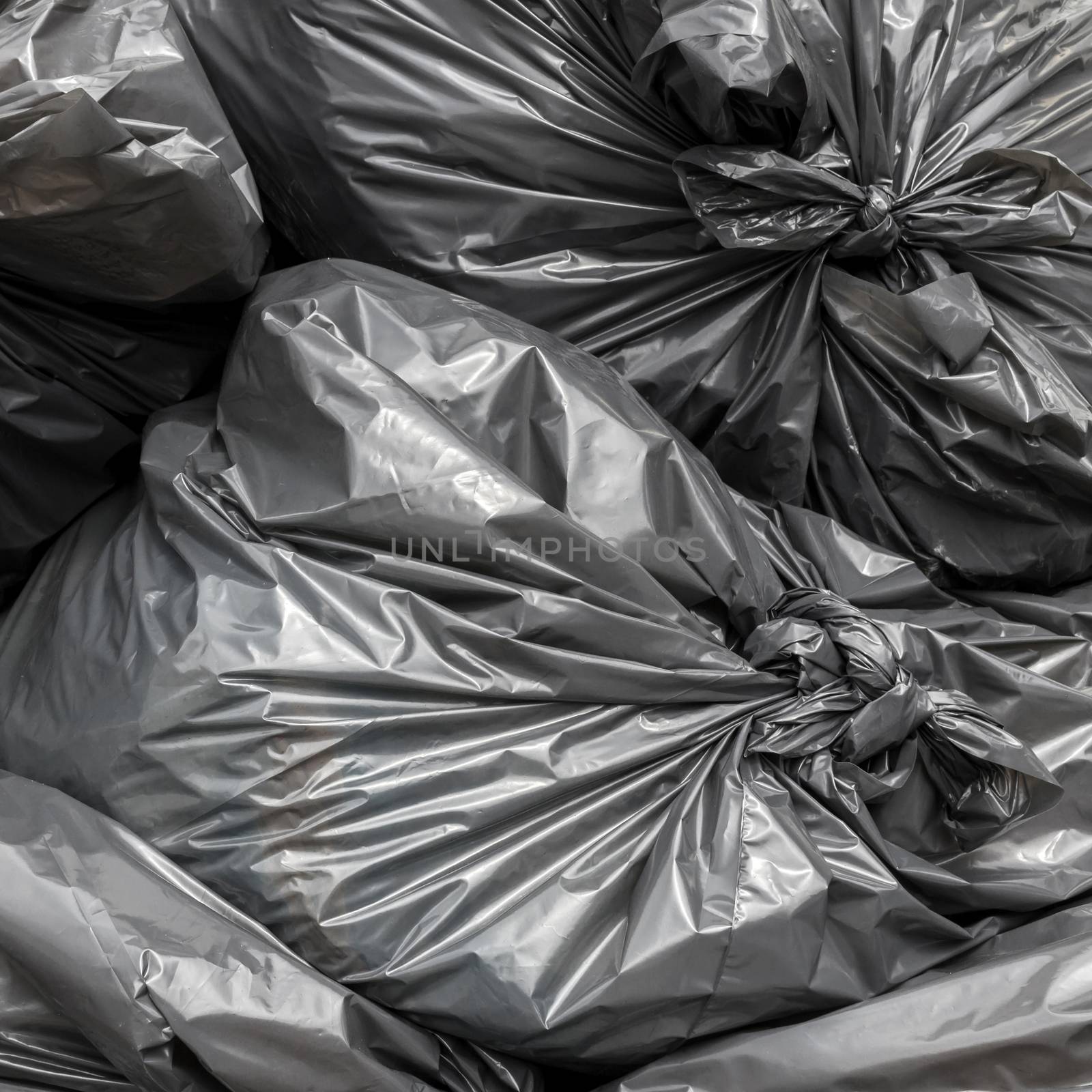 Pile of black garbage bags. Close-up for background.