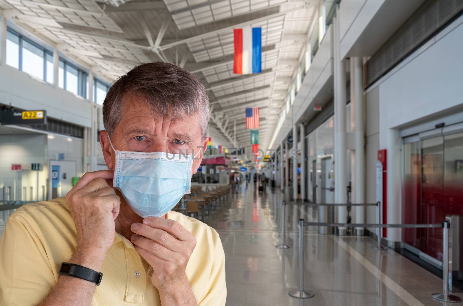 Senior adult man adjusting face mask in airport and looking very worried by steheap