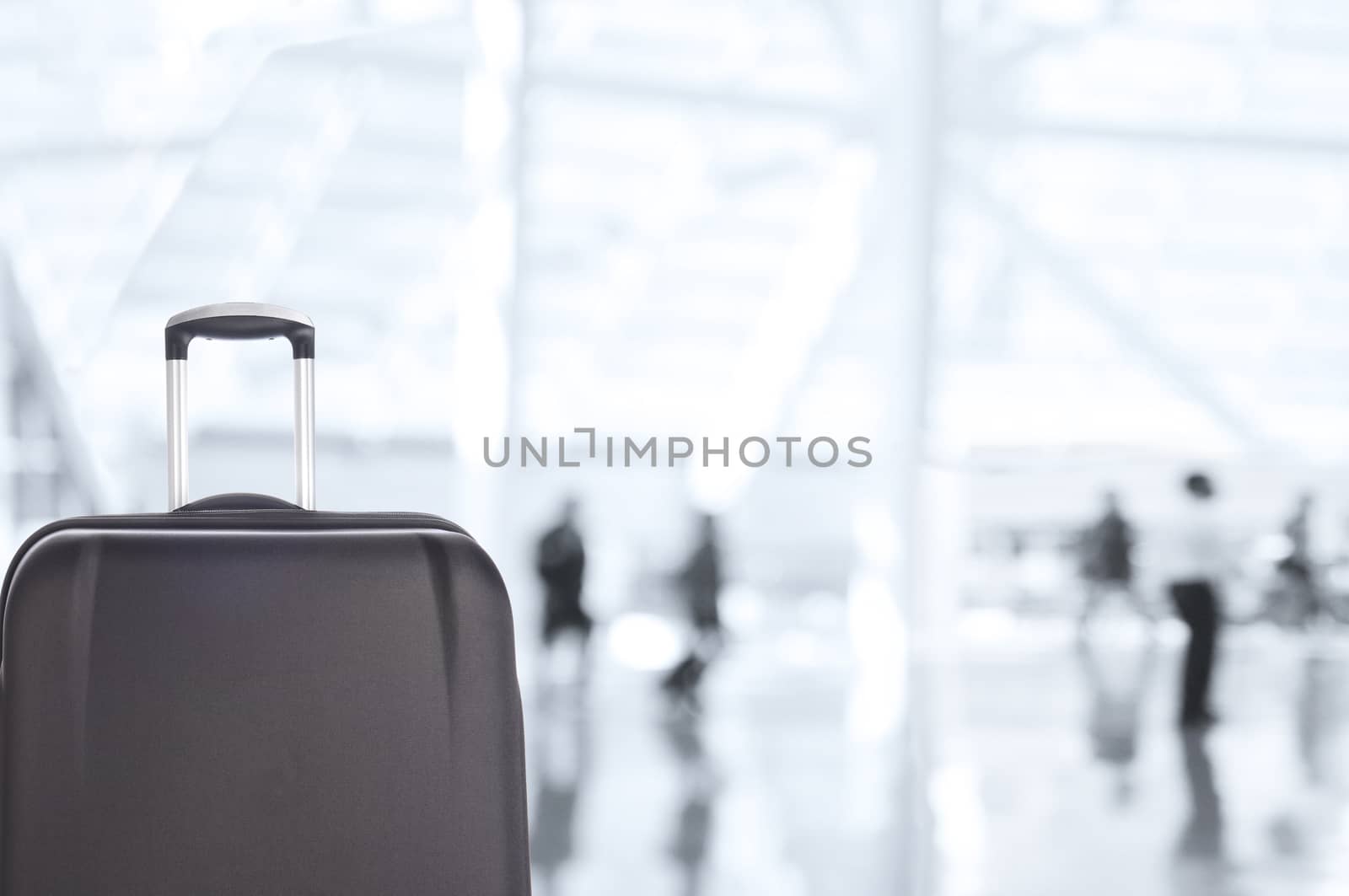 Luggage Closeup with Blurred Travelers in Airport Concourse by sCukrov