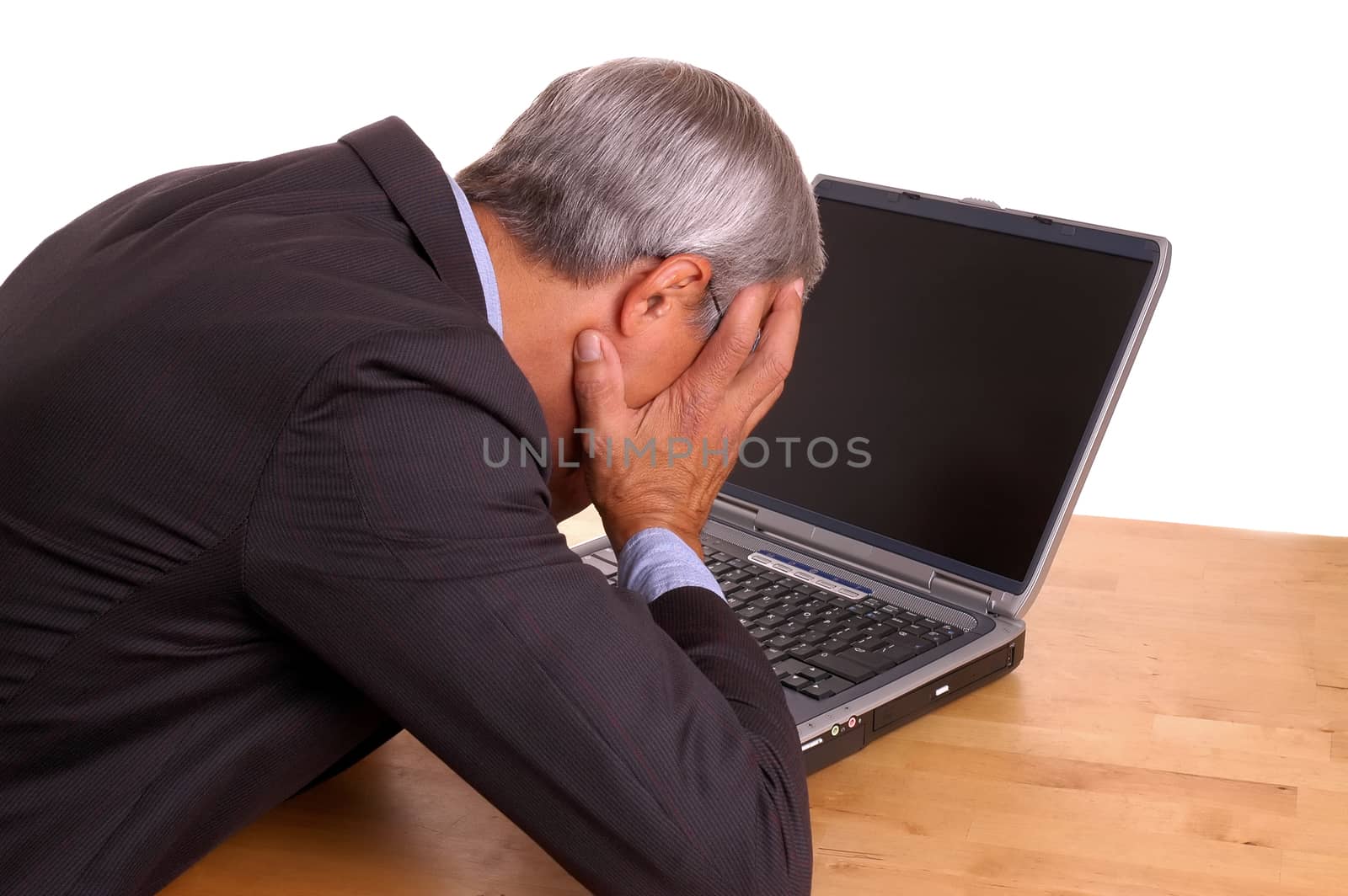 Frustrated Businessman, with head in hands at laptop isolated on white