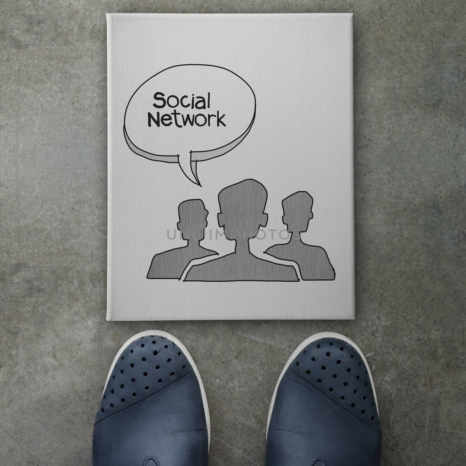 Hand drawn people social network icon on canvas board on front of business man feet as concept