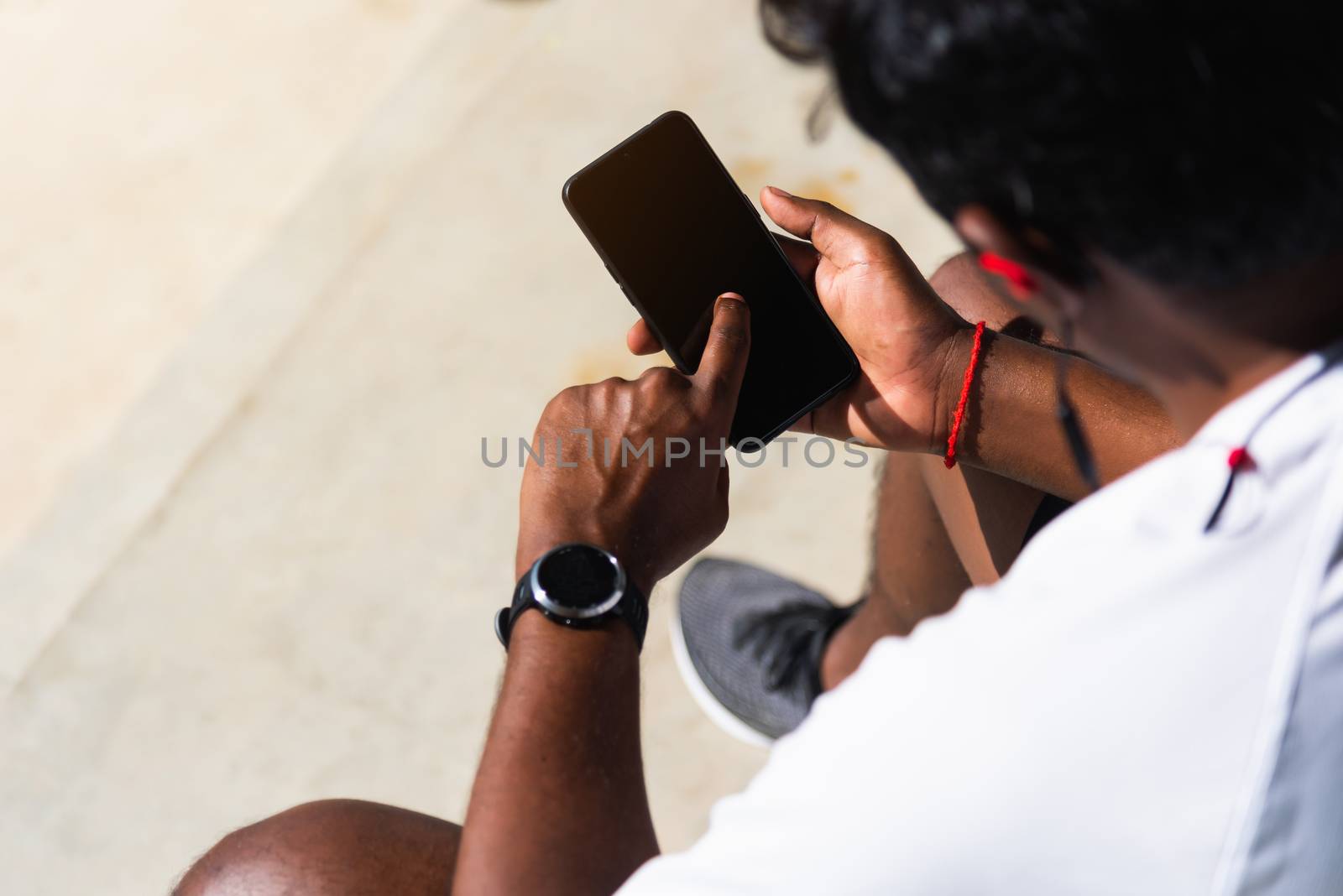 Close up Asian young athlete sport runner black man wear modern time smart watch and sync to a smartphone check running result after training run at the outdoor, healthy exercise workout technology