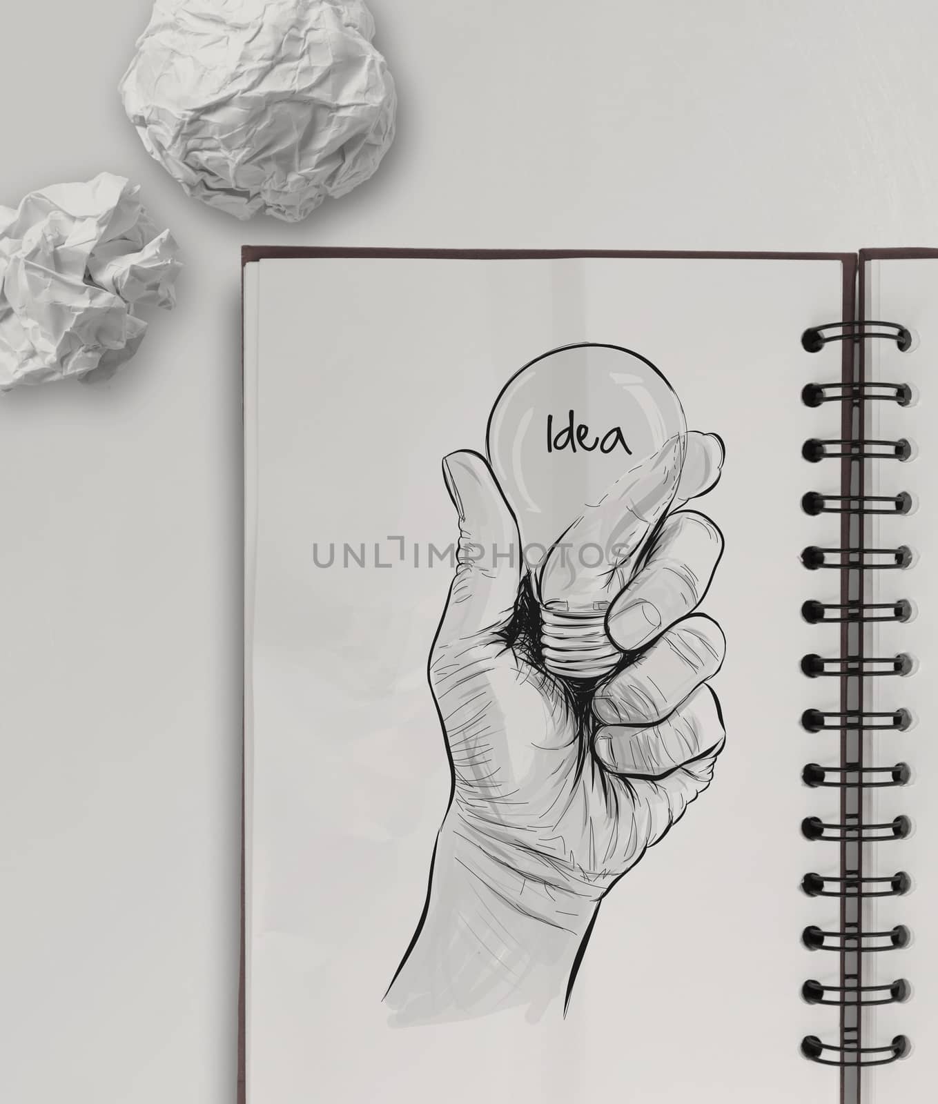 Hand drawn light bulb with IDEA word on note book as concept