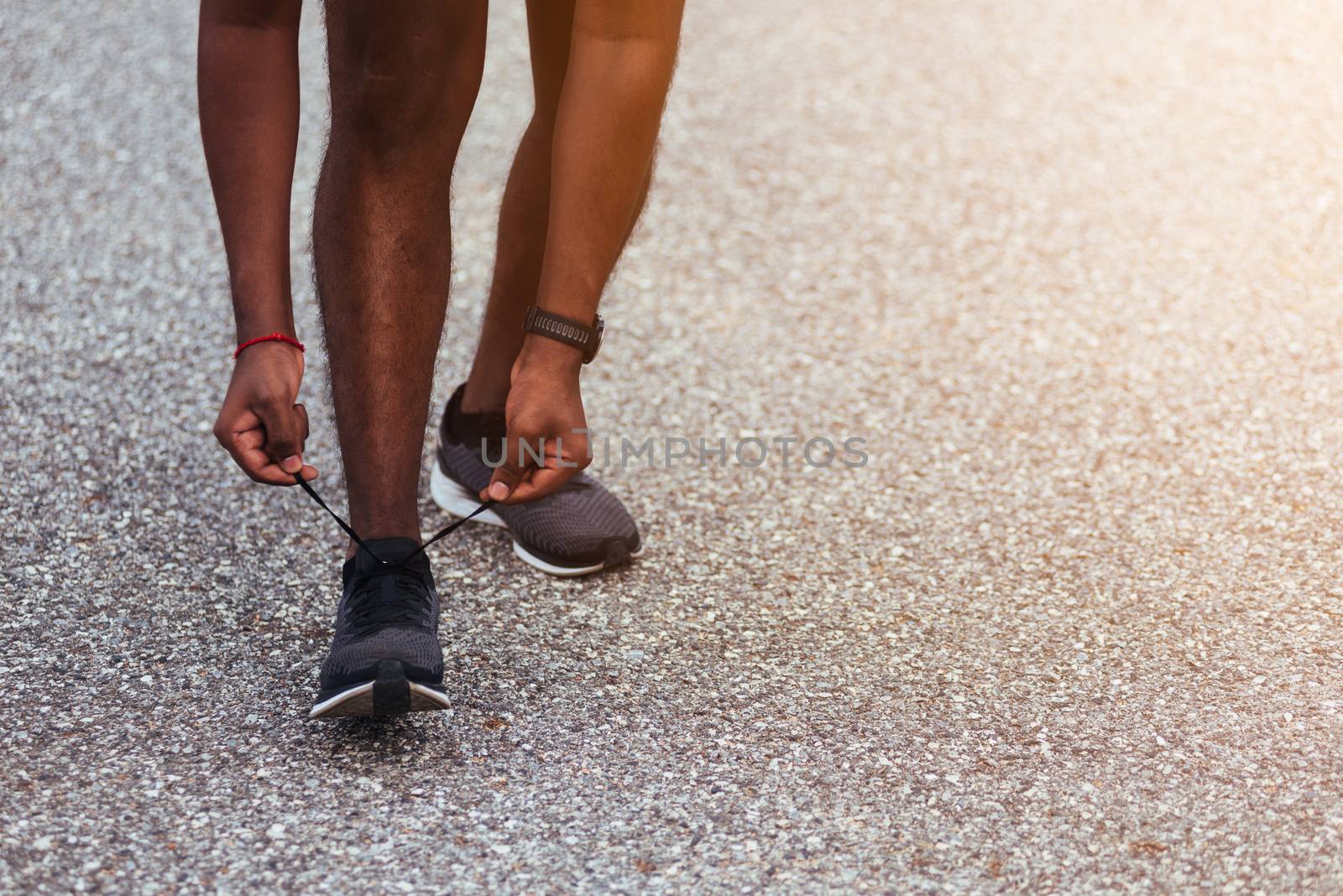 Close up Asian sport runner black man standing he trying shoelace running shoes getting ready for jogging and run at the outdoor street health park, healthy exercise workout concept