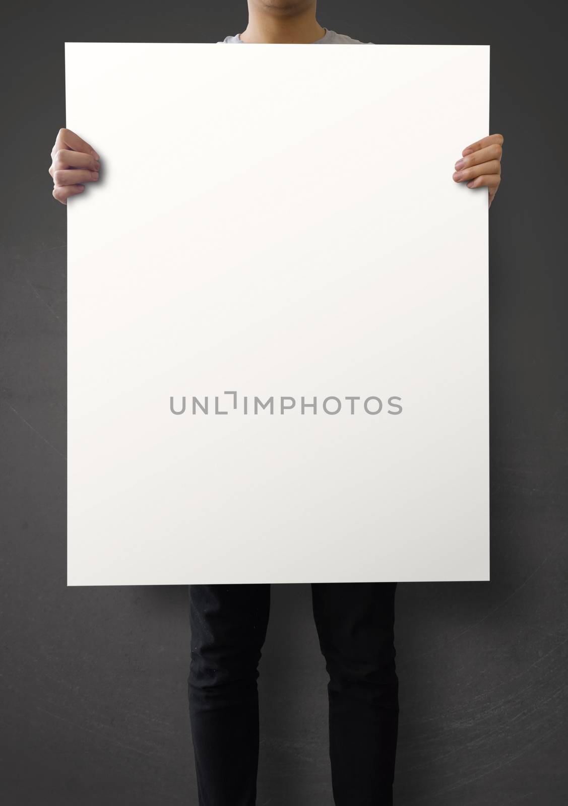 hipster holding blank poster on texture wall as concept  by everythingpossible