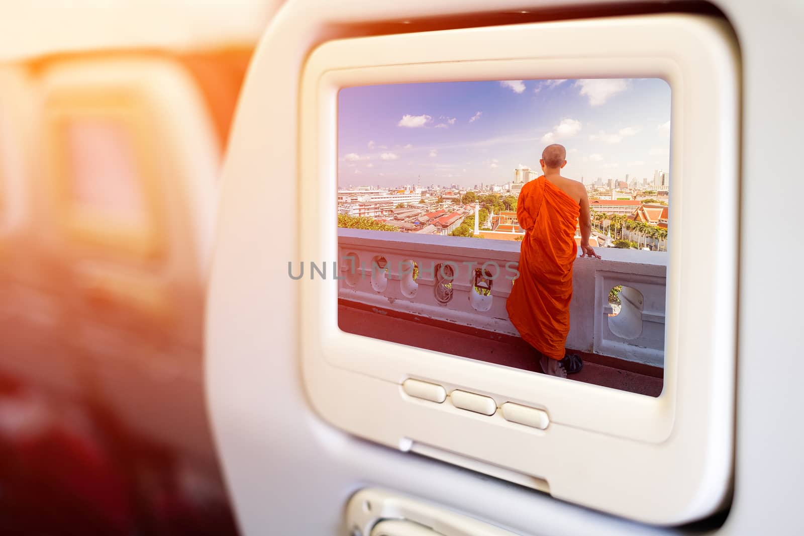 Aircraft monitor in front of passenger seat showing Unidentified buddhist monks in City view point at Golden moutain Temple, Thailand