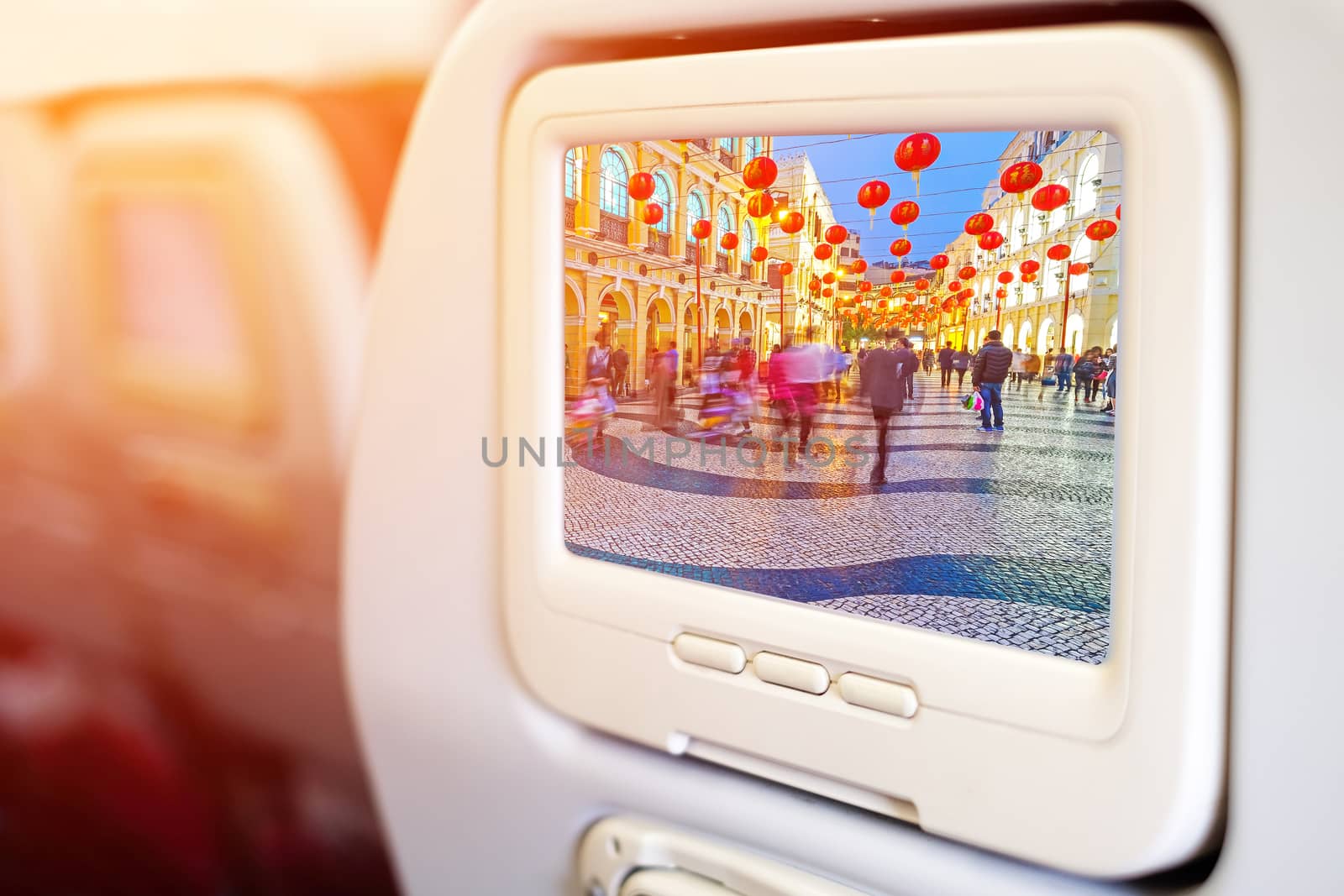 Aircraft monitor in front of passenger seat showing Senado Square nigth view of Macau