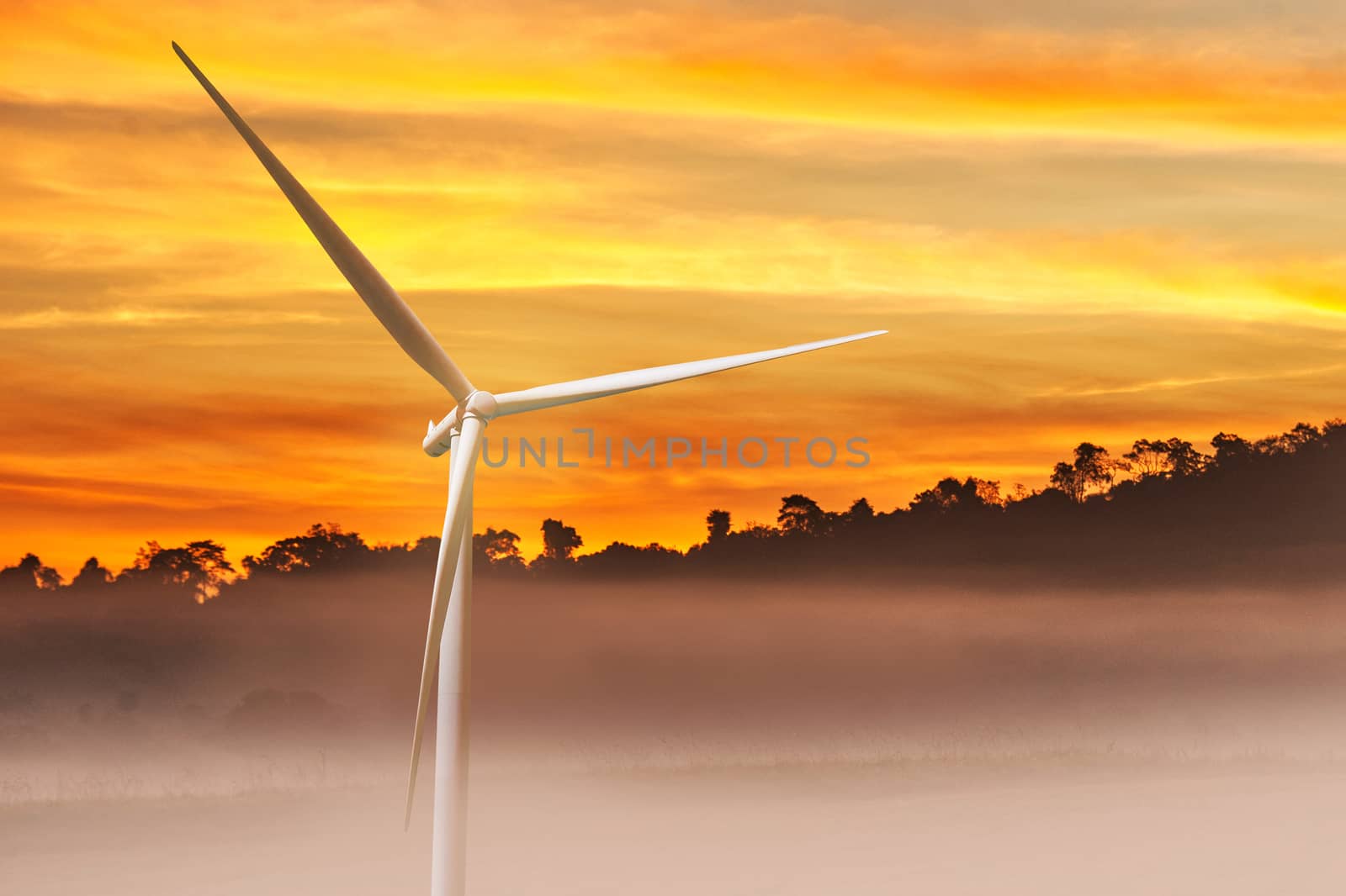 Wind turbine power on the sunrise in mountain background by Surasak