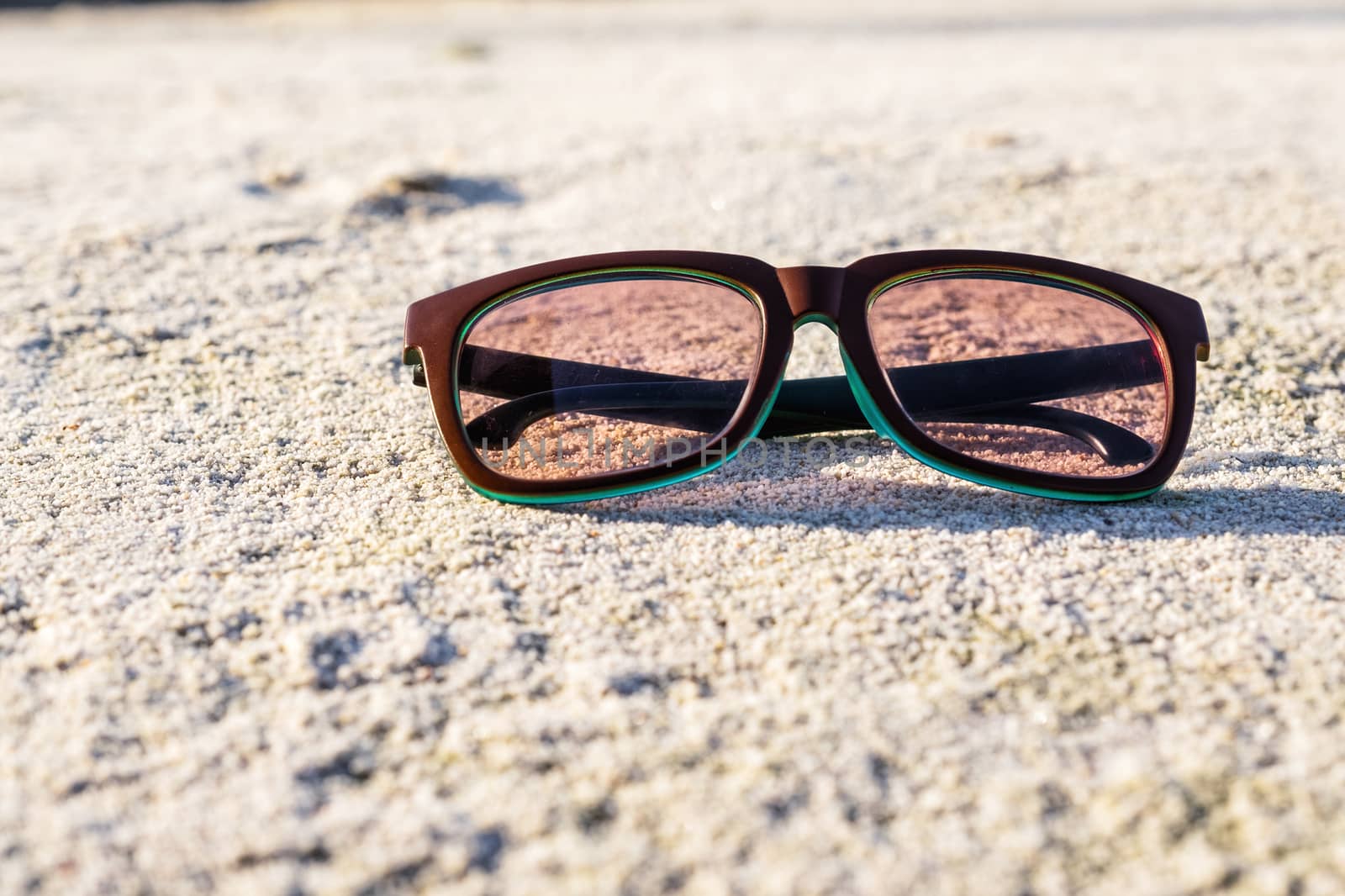 Black Sunglasses on the beach by Surasak