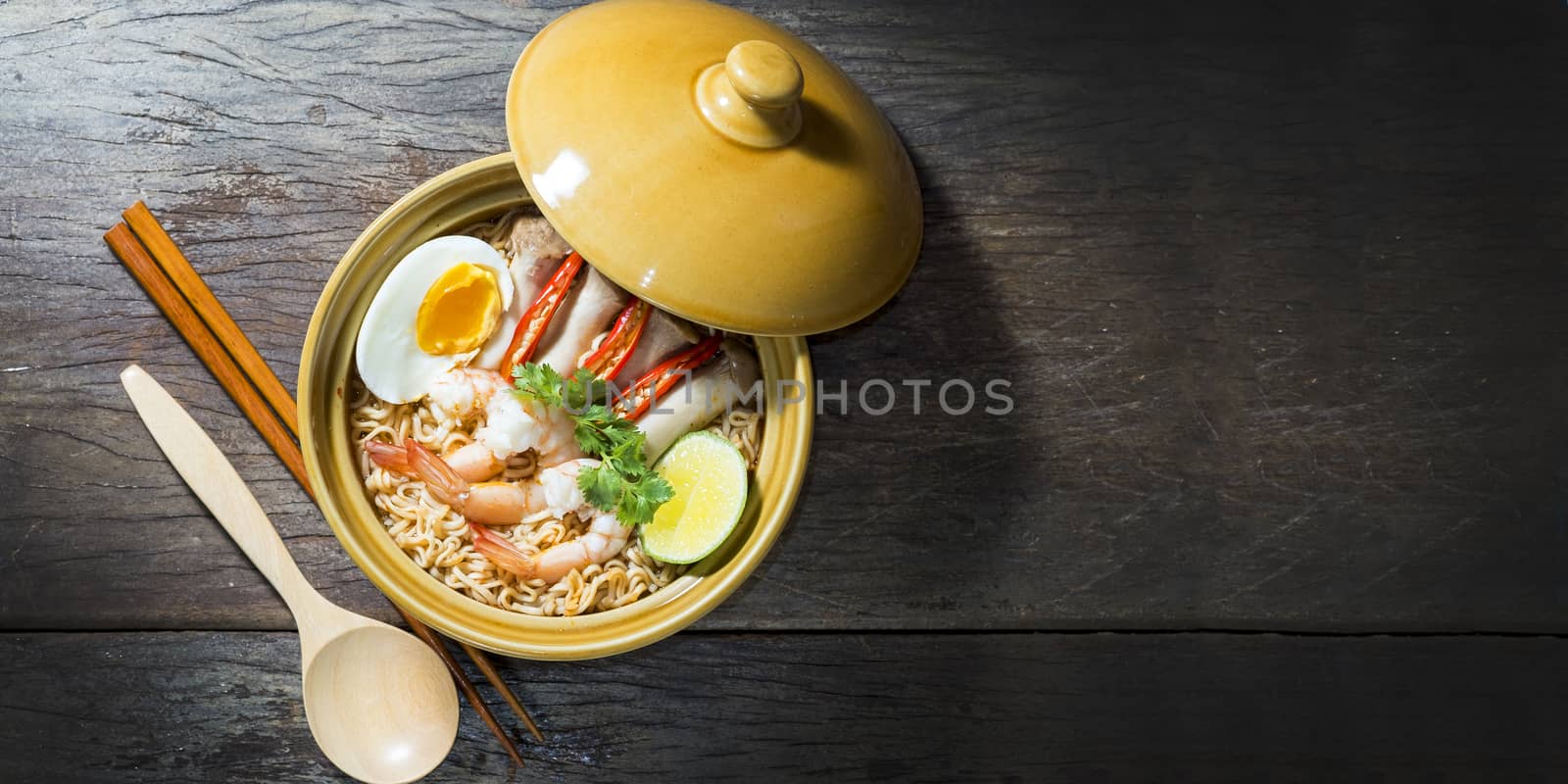 Thai food style noodle, tom yum kung on wood background by Surasak