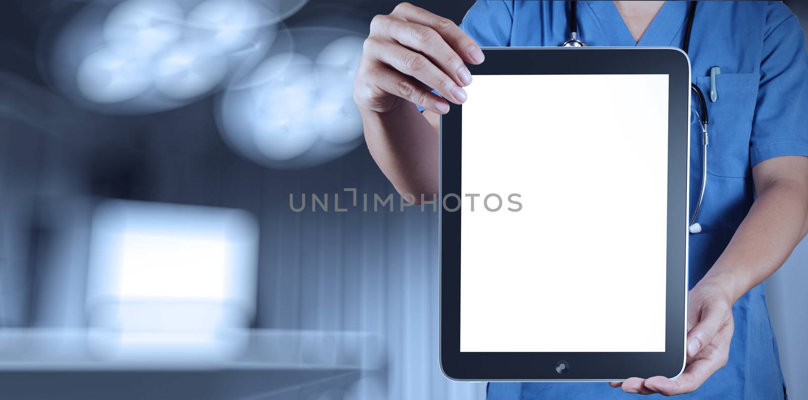 Doctor working with tablet computer with operating room by everythingpossible