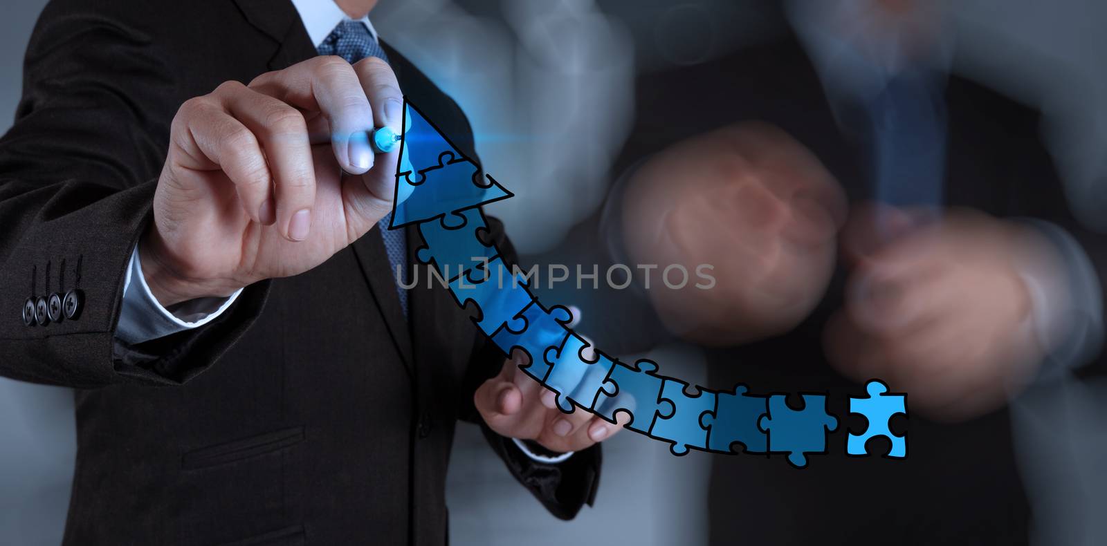 businessman hand puzzle charts with new modern computer and business strategy as concept 