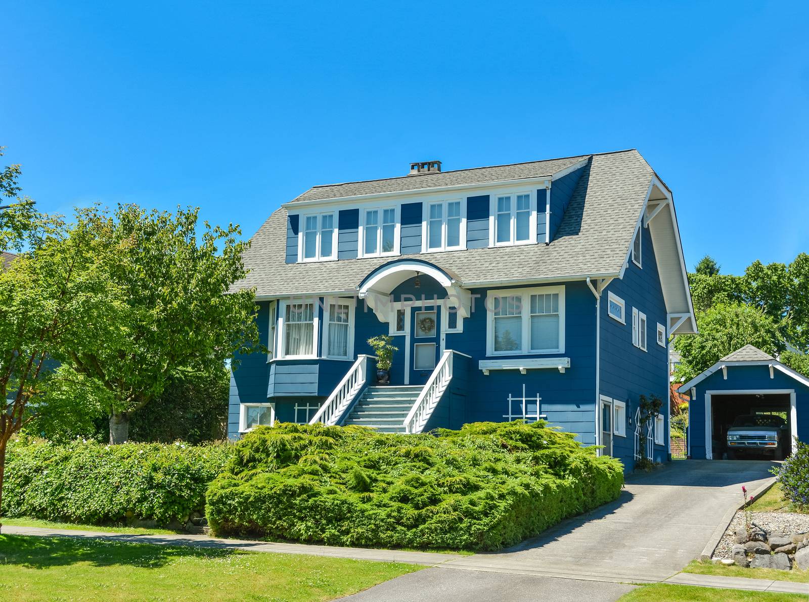 Big North American family house with detached garage in suburbs of Vancouver. A house on blue sky background