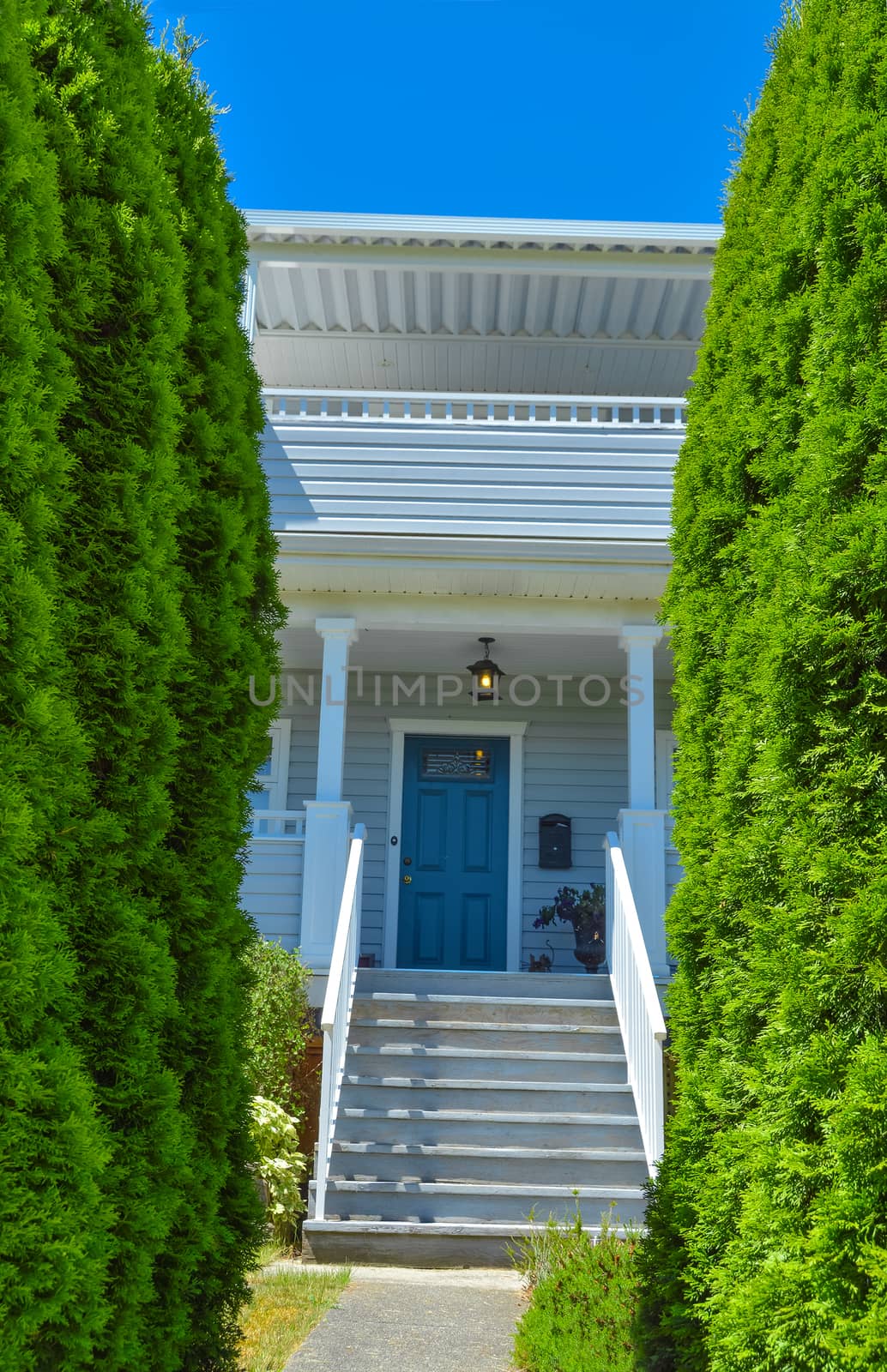 Iron gate in front of residential house with steps and pathway leading the entrance