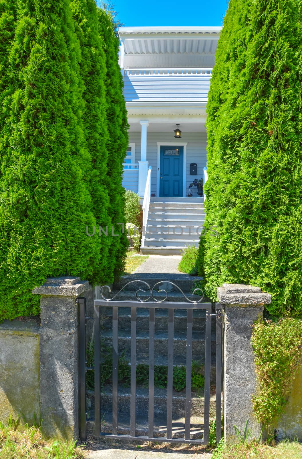 Iron gate in front of residential house with steps and pathway leading the entrance