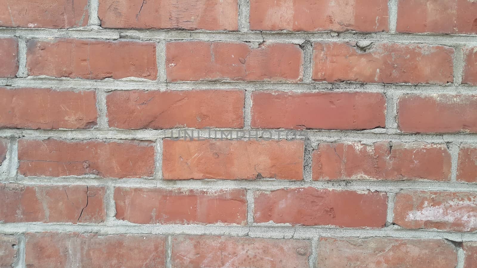 Closeup texture of red brick wall. A background of a weathered old exterior brick wall in the sunshine.