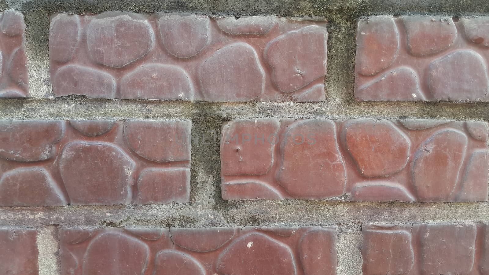 A background of a weathered old exterior brick wall in the sunshine. by Photochowk