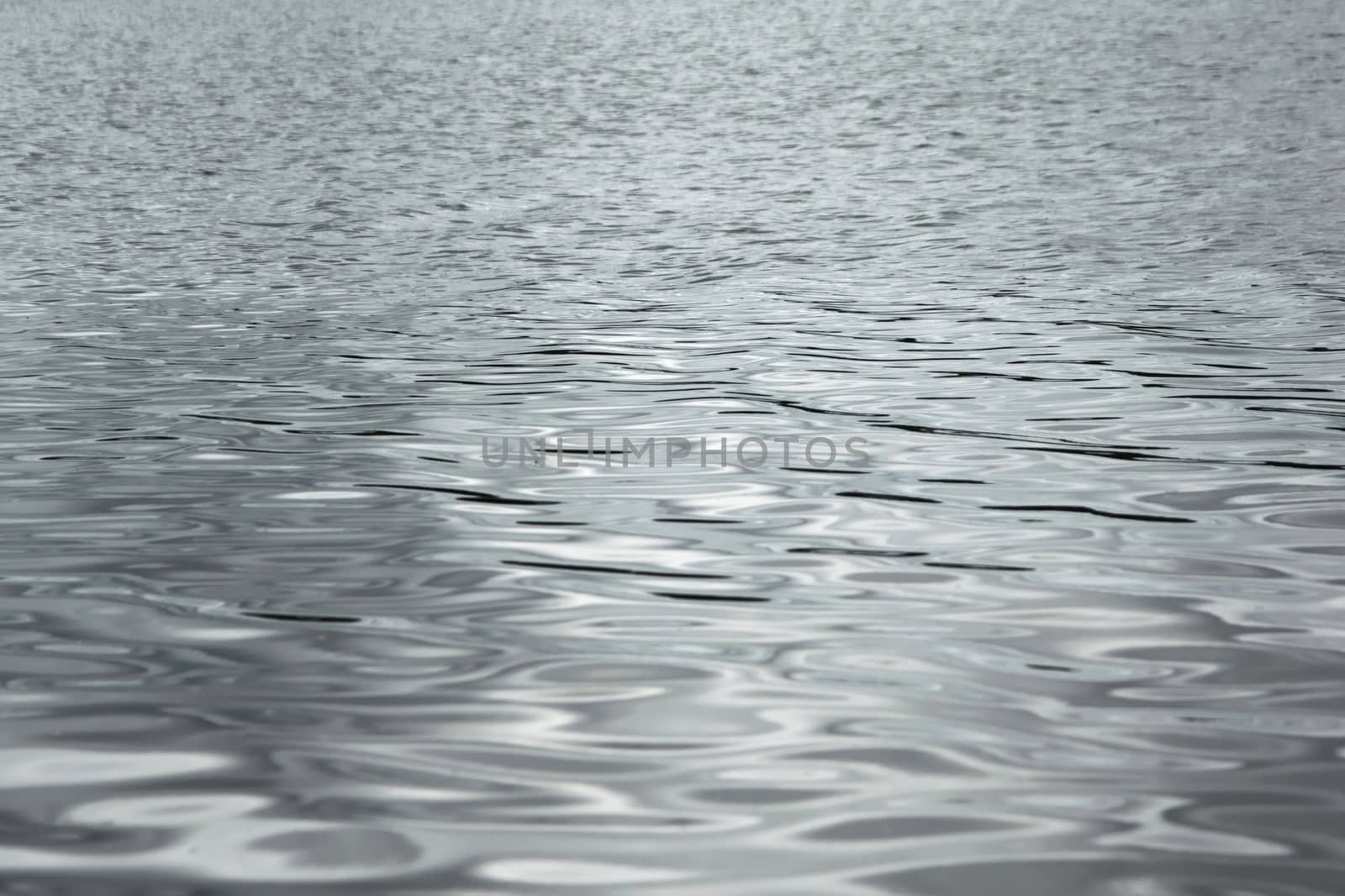 Silver reflections on the waters of a lake. Full frame texture detail.