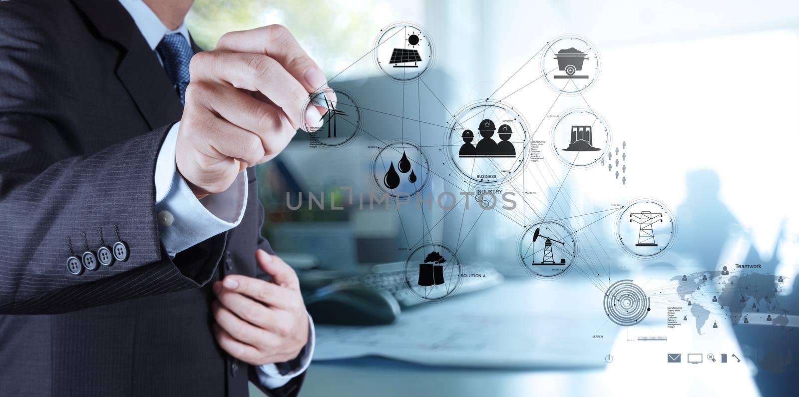 businessman hand touch Wind turbines with his office background