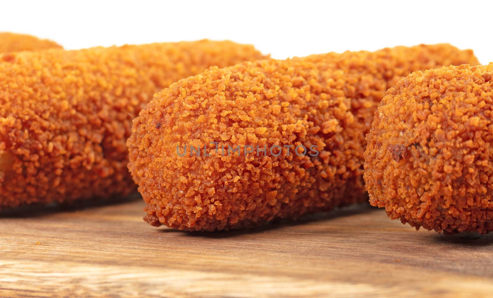 Brown crusty dutch kroketten on a serving tray, selective focus, isolated